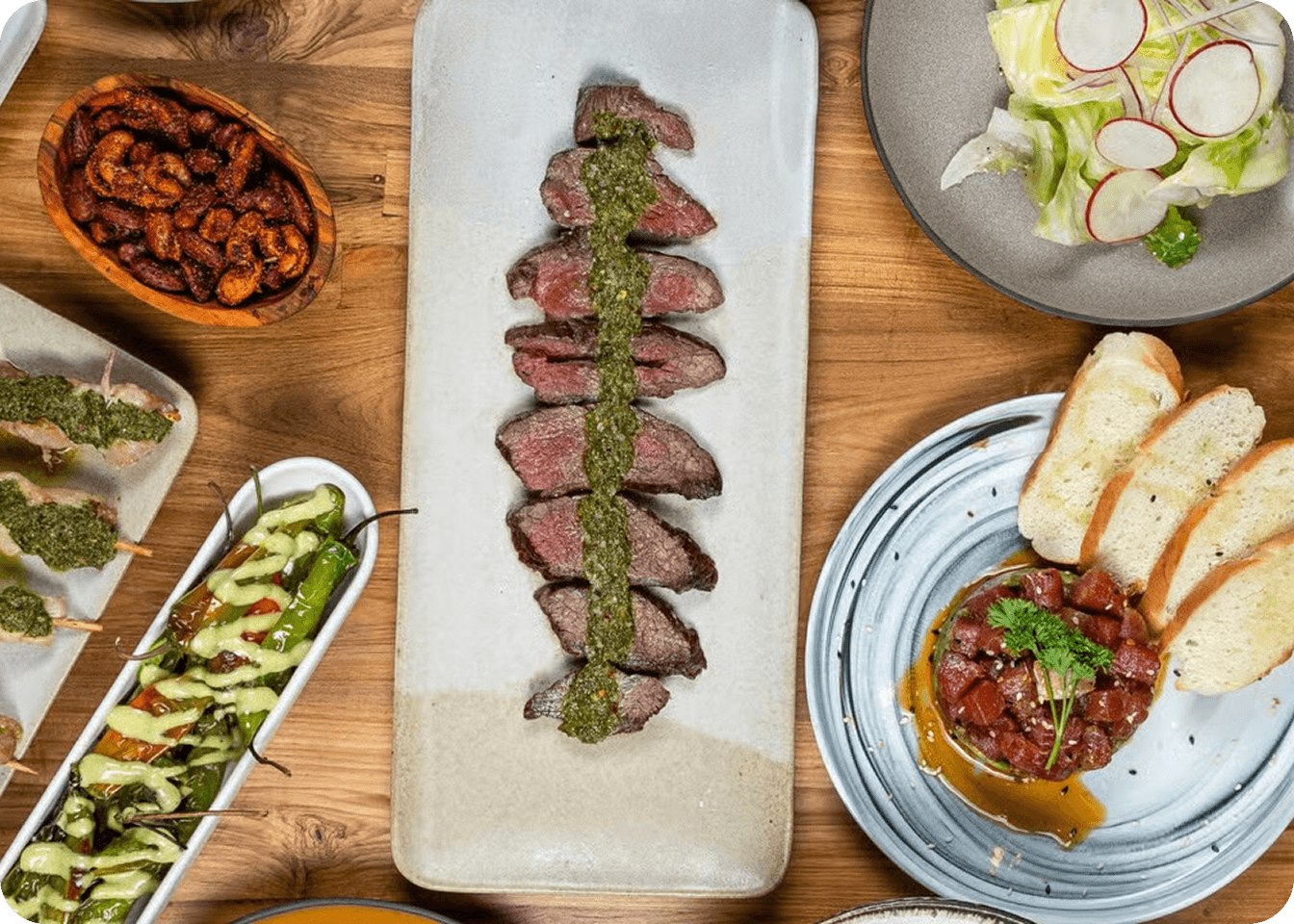 Overhead view of a Mediterranean small plate spread on a wooden table.