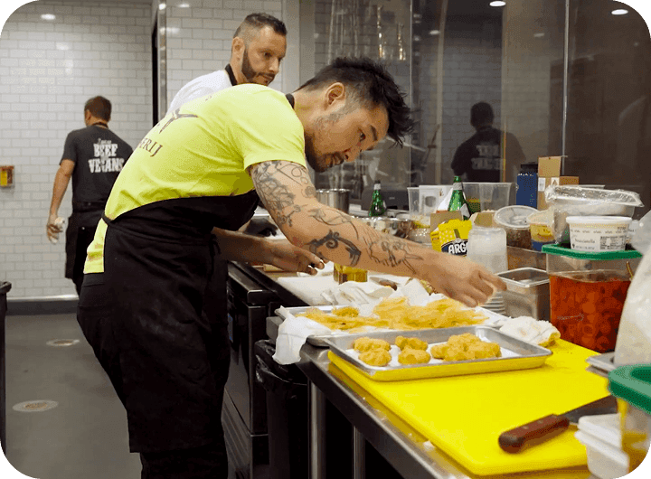 Soo Ahn, Chef & Partner of Adalina Prime, plating fried dishes in the kitchen