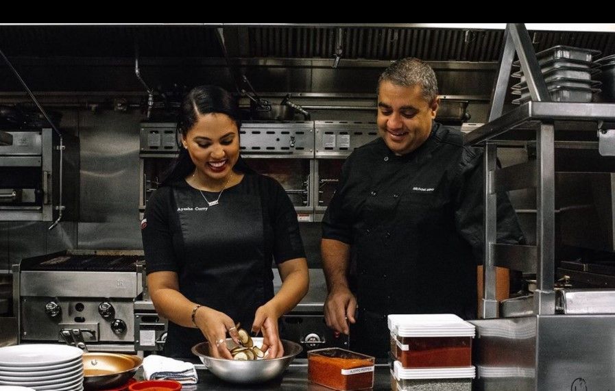 Chef Ayesha Curry and Chef Michael Mina in the kitchen at International Smoke.