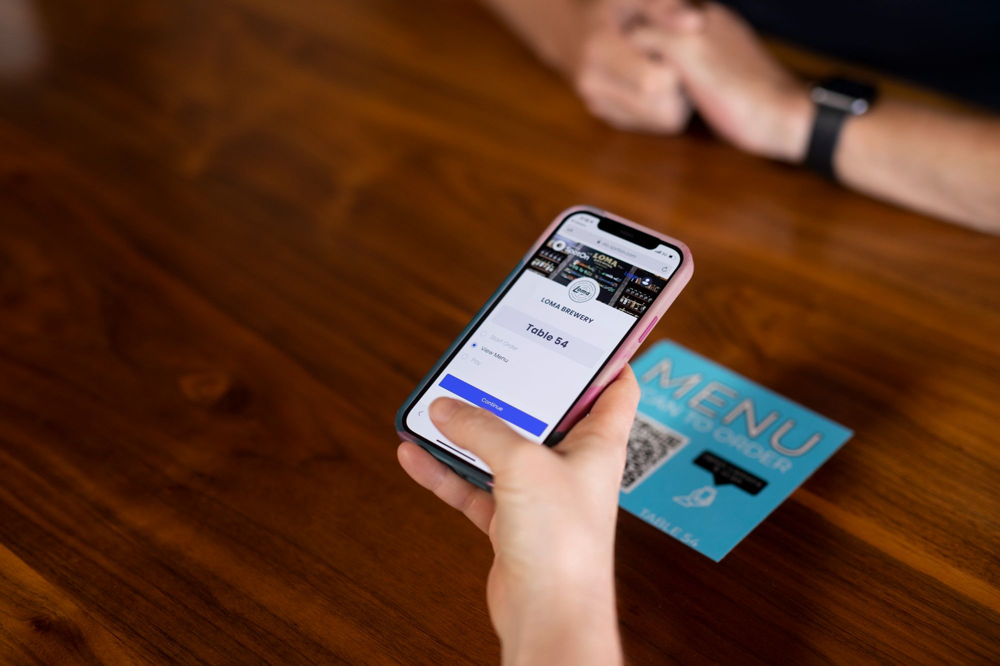 A guest using their phone to order using SpotOn QR ordering at Loma Brewery.