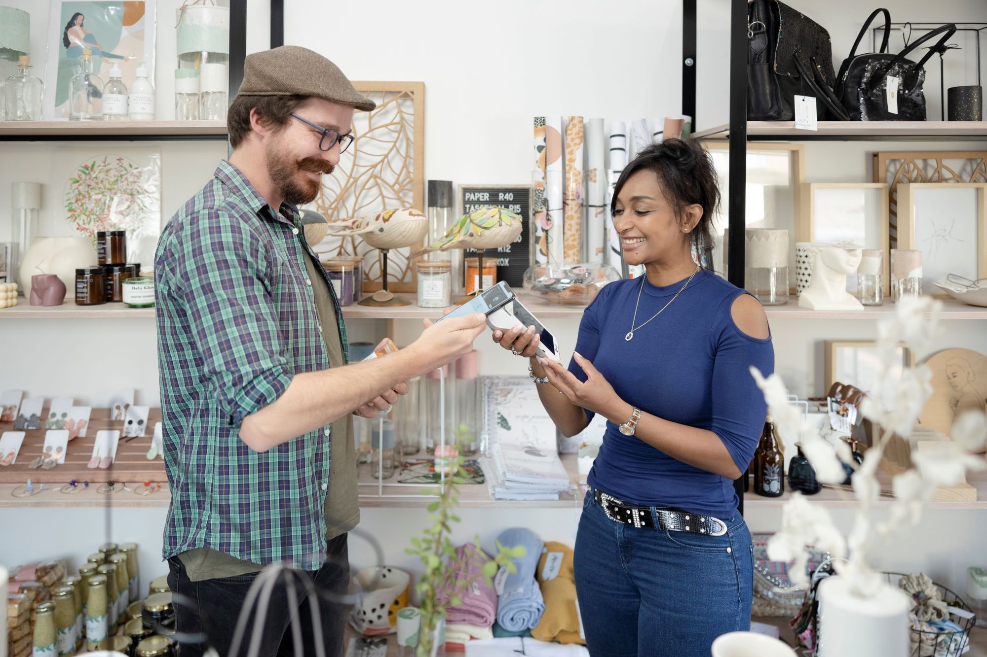 Retail boutique owner helping a customer pay with a mobile POS device.