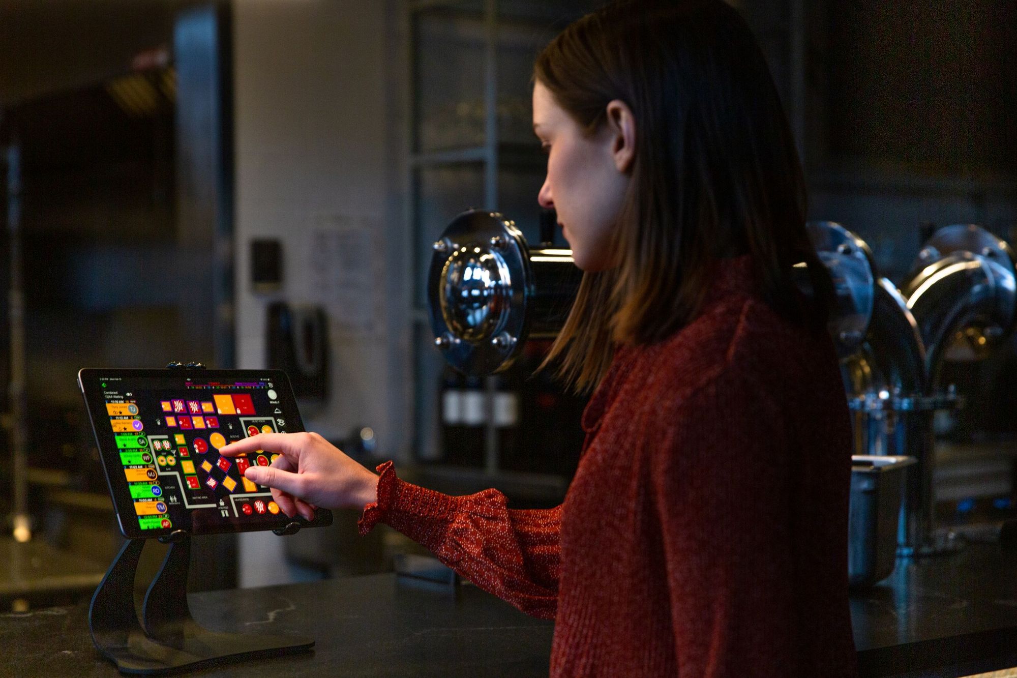 A restaurant host checks on the table status from a tablet using SpotOn Reserve