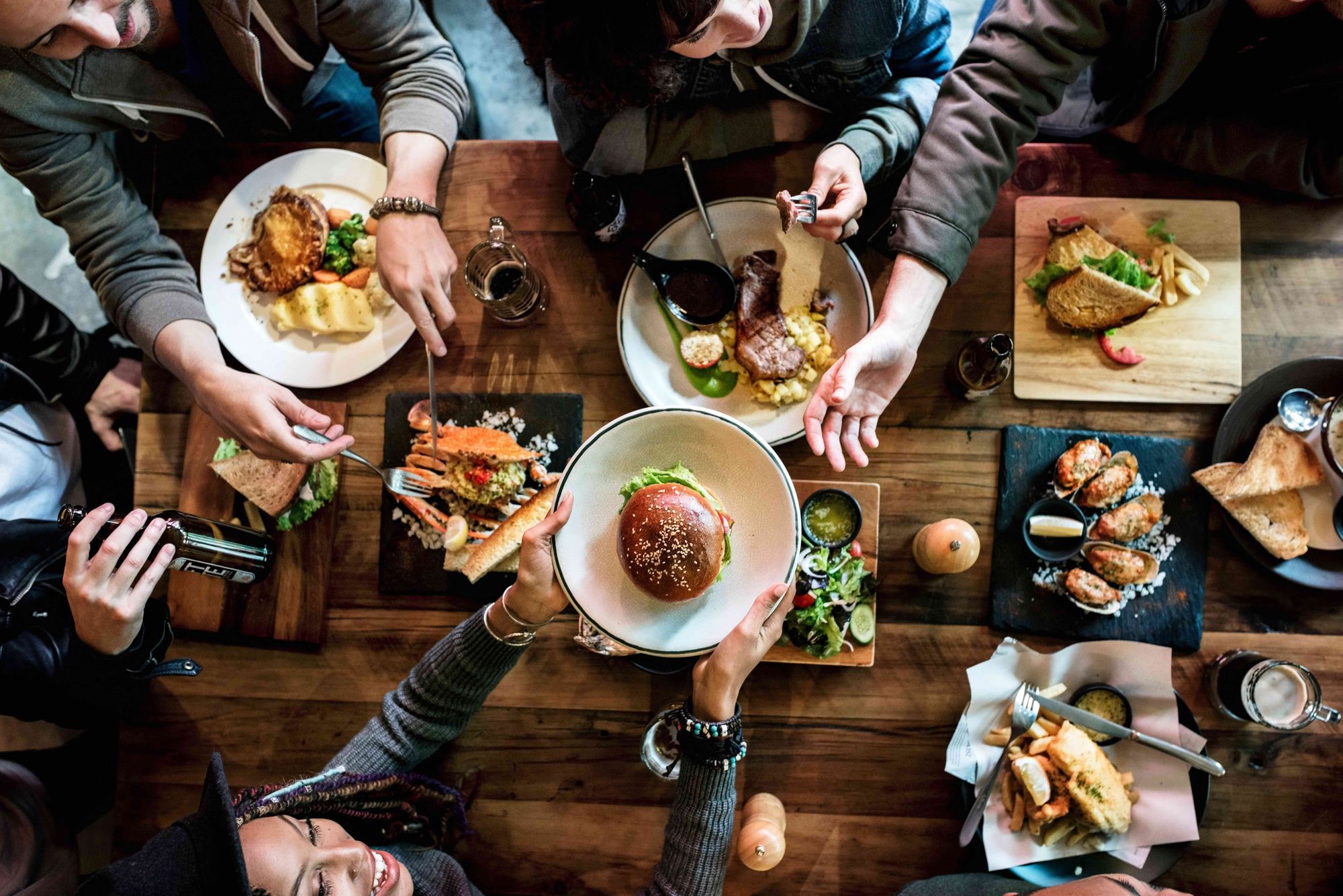 Top view of a party at a restaurant sampling different menu items.