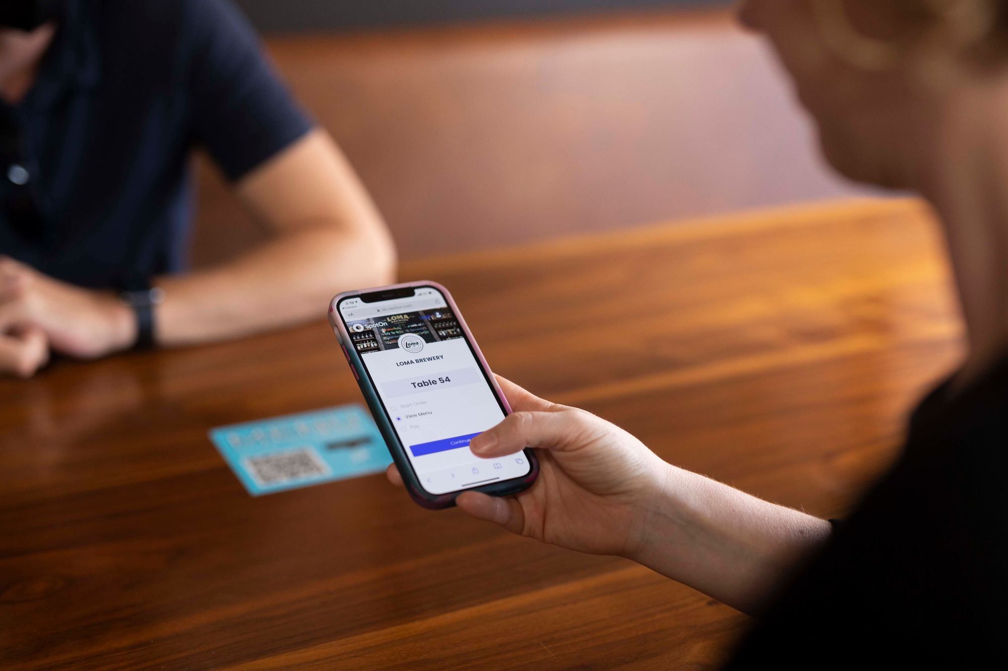 A guest pointing a smartphone at a QR code and viewing the menu.