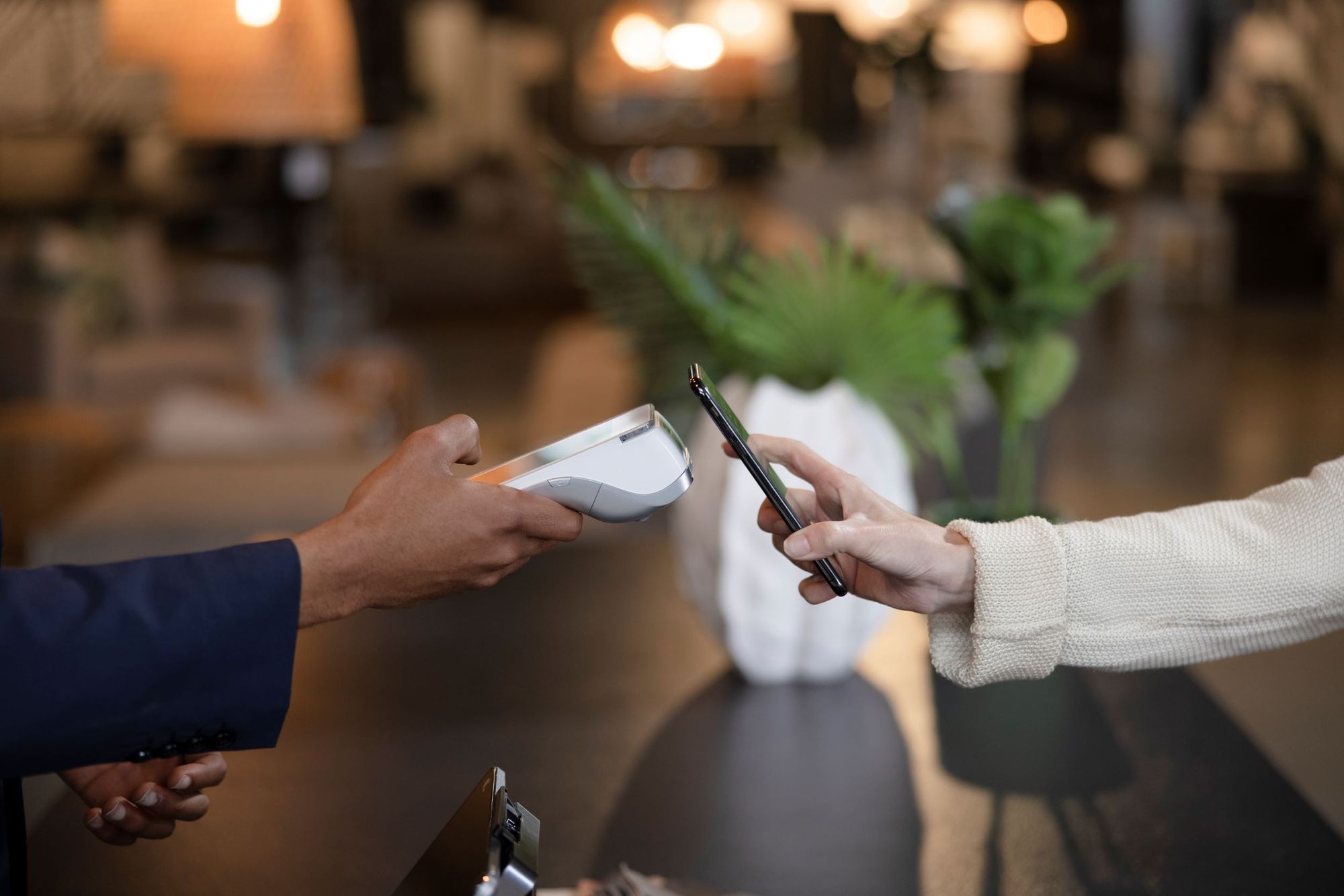 A customer taps their phone to handheld retail POS device