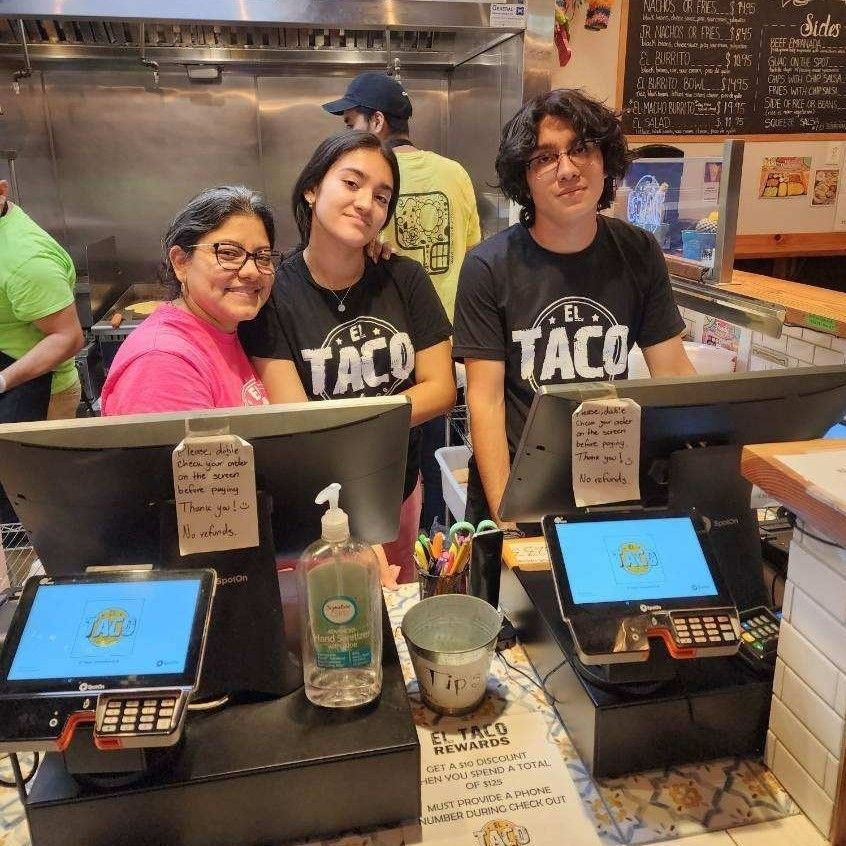 El Taco's owner stands behind the cash register with her two teenage children