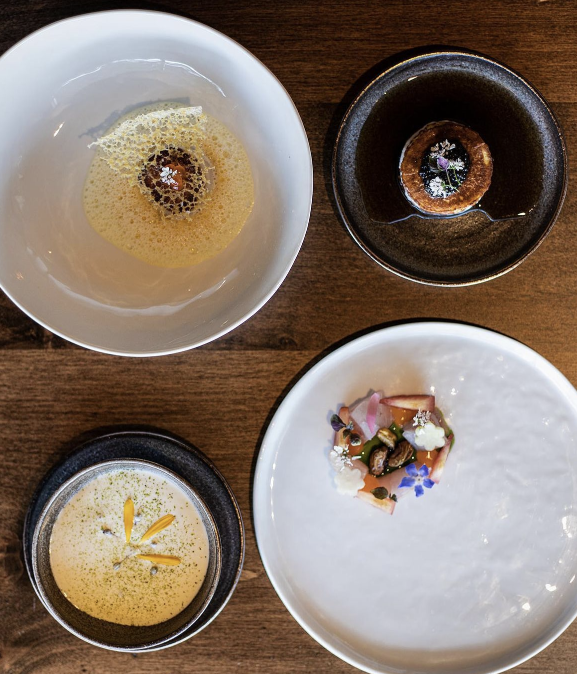Four beautifully plated dishes at Table Culture Provisions