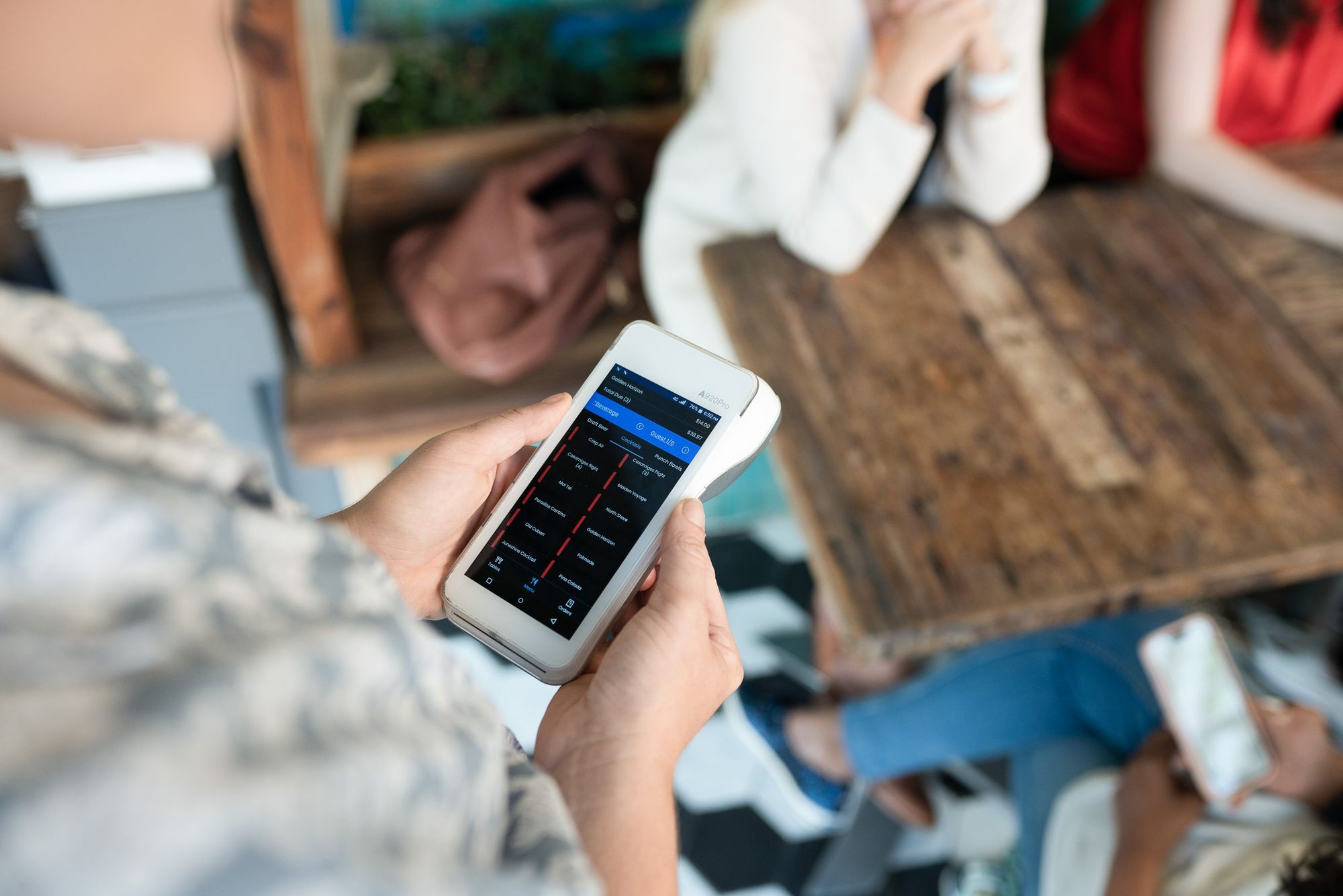 A cup of coffee next to a SpotOn point-of-sale handheld system.