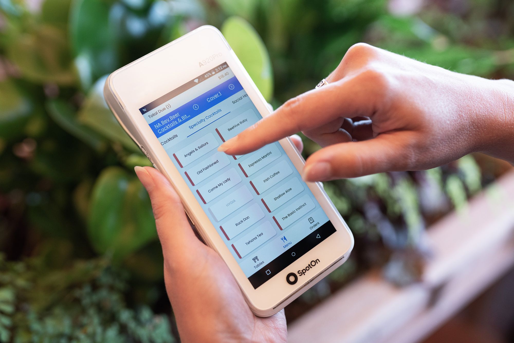 A restaurant server places an order from a handheld POS device