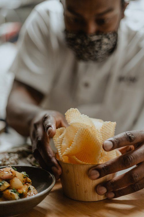 A chef plates a side dish at Table Culture Provisions