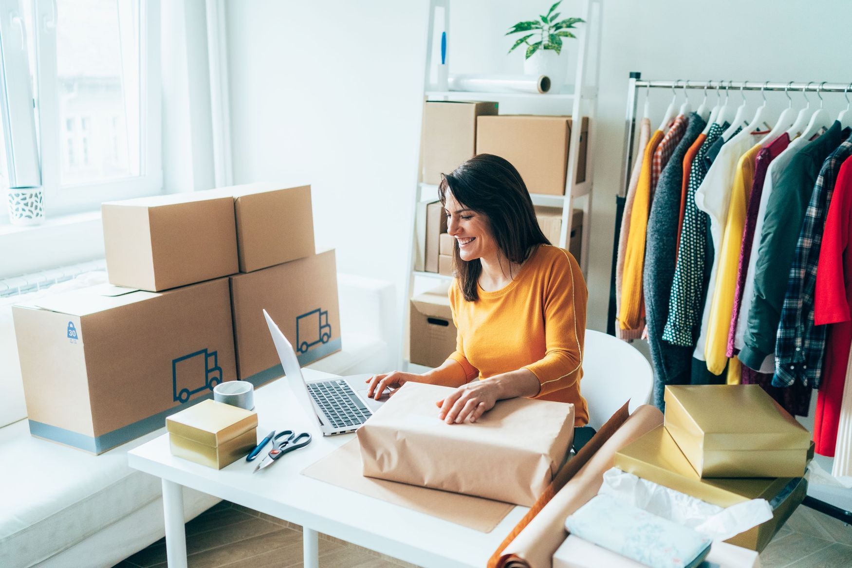 A happy business owner works on her laptop