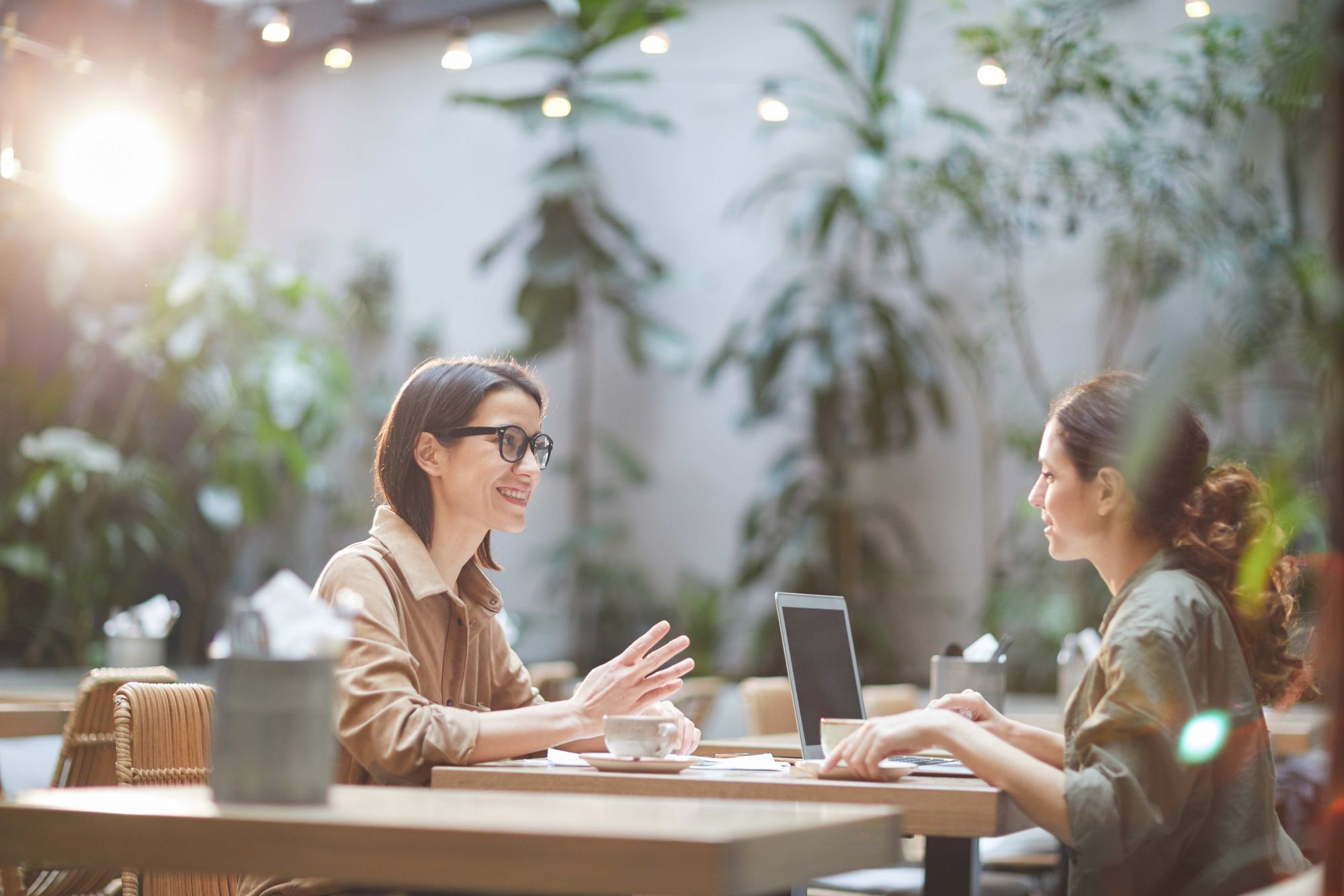 Two women at a restaurant having a discussion about their vision.