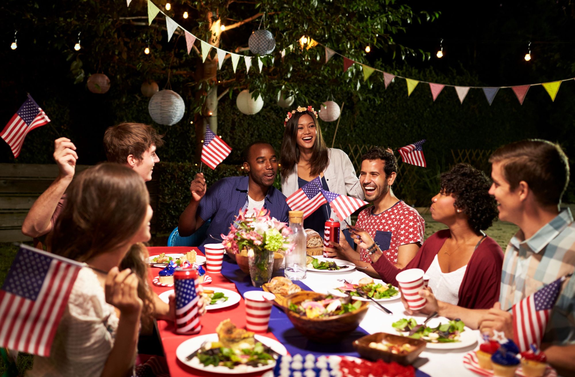 Group of people celebrating Fourth of July while eating. 