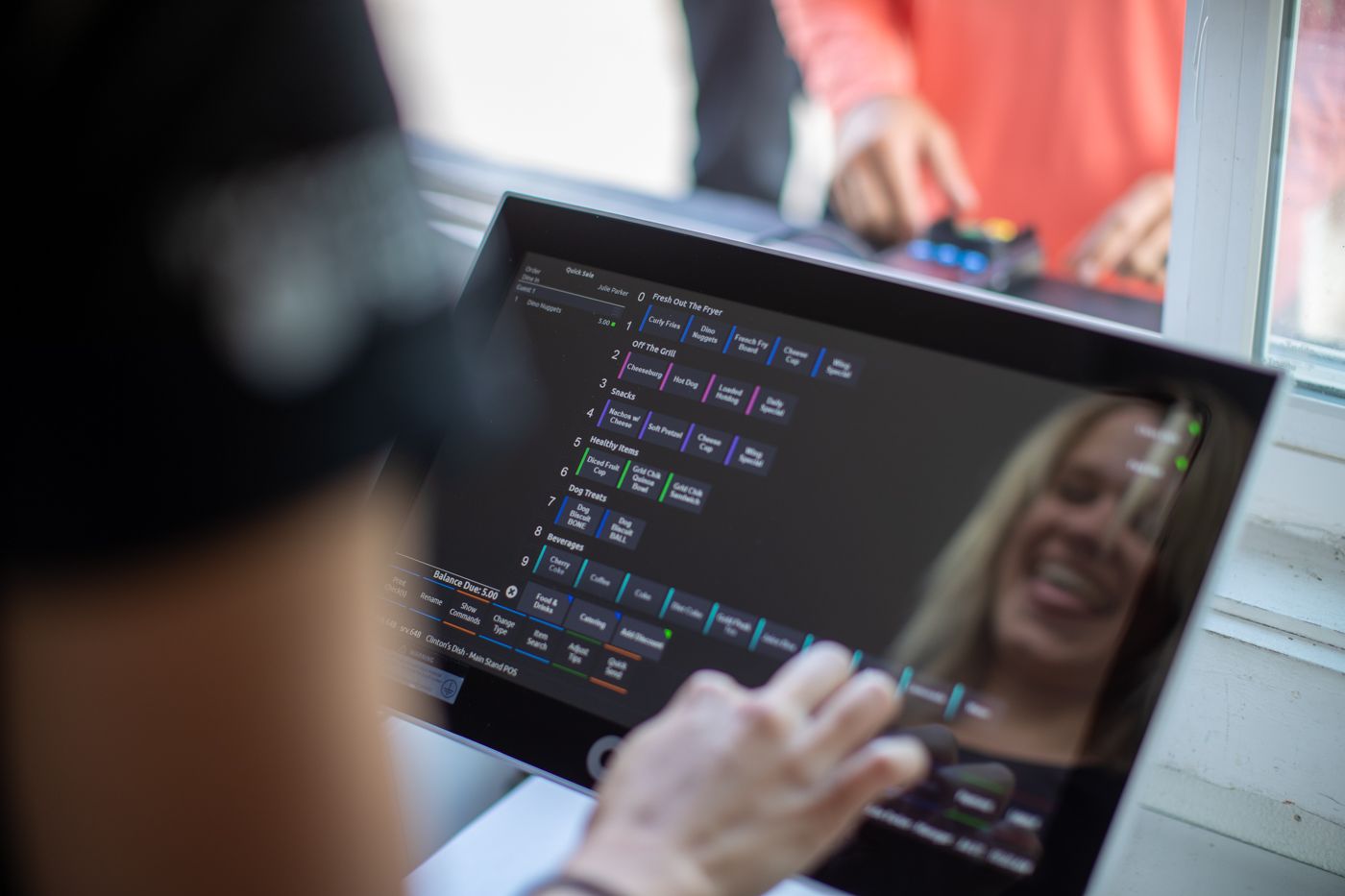 Woman smiling as she completes an order on her cloud based POS.