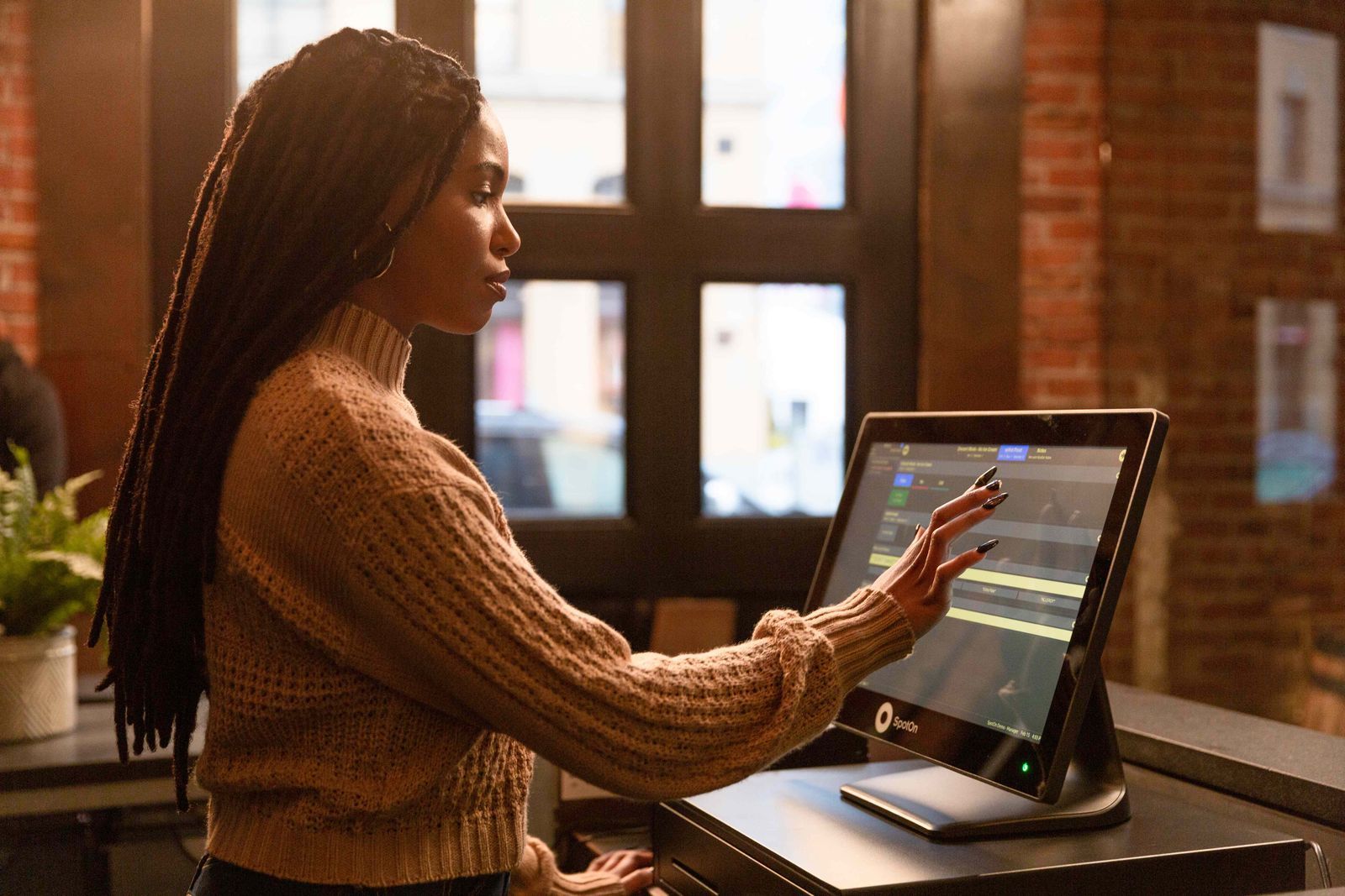 A restaurant server views incoming online orders right from an integrated SpotOn Restaurant POS station