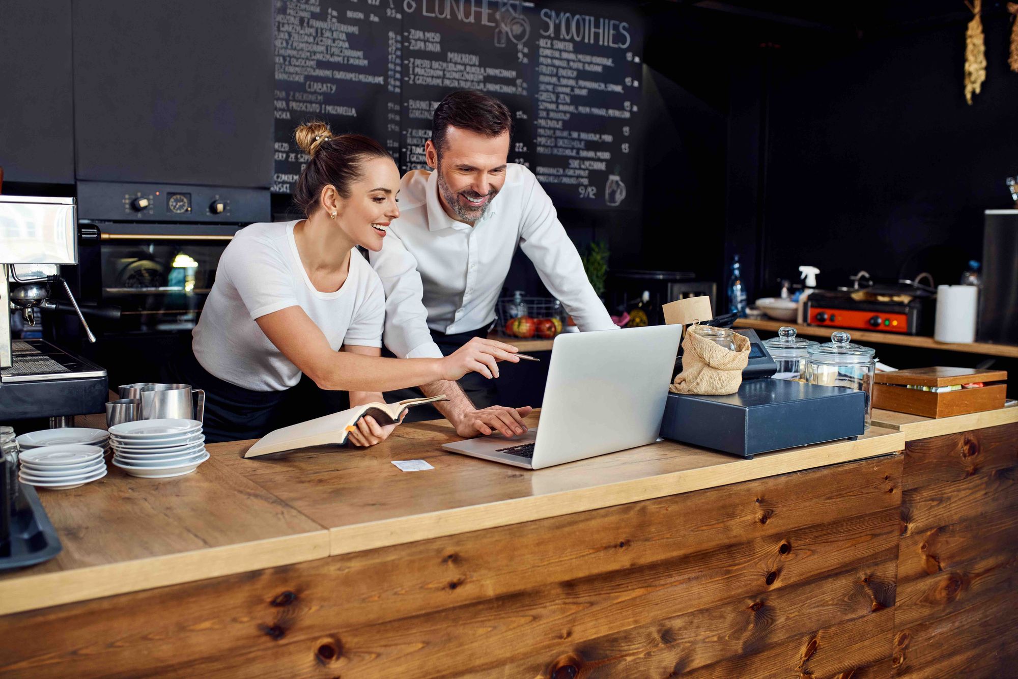 Two managers are looking at a computer analyzing their data reports.