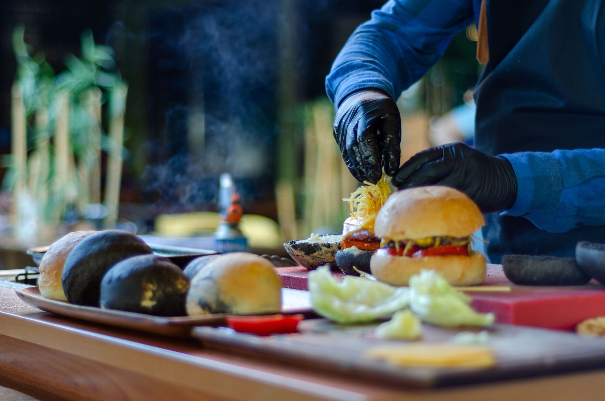 A cook prepares a plate of burgers at a pop-up restaurant