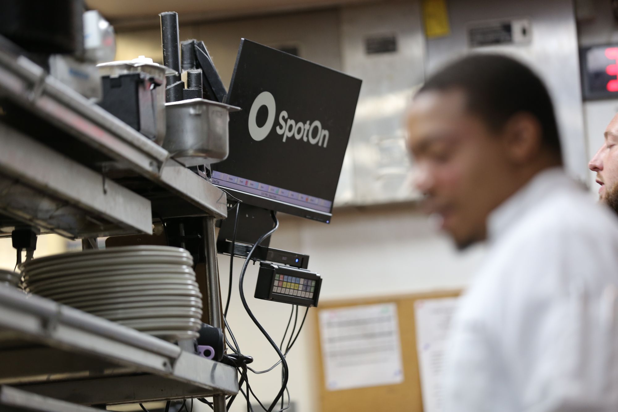 Two restaurant cooks use a kitchen display system to prepare orders