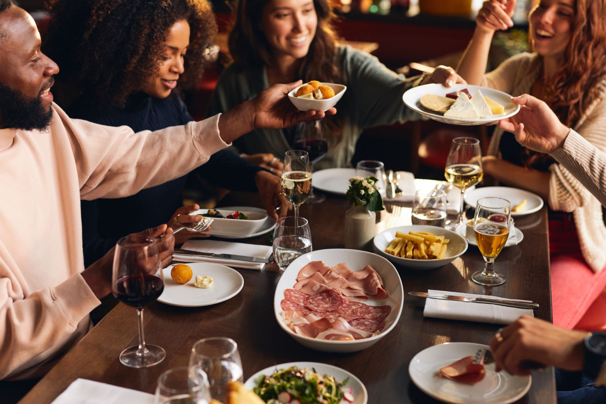 Group of diners share plates of food in a restaurant.