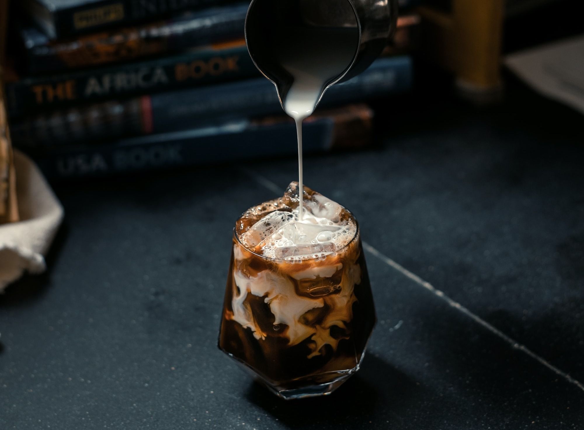 a person pours something into a glass