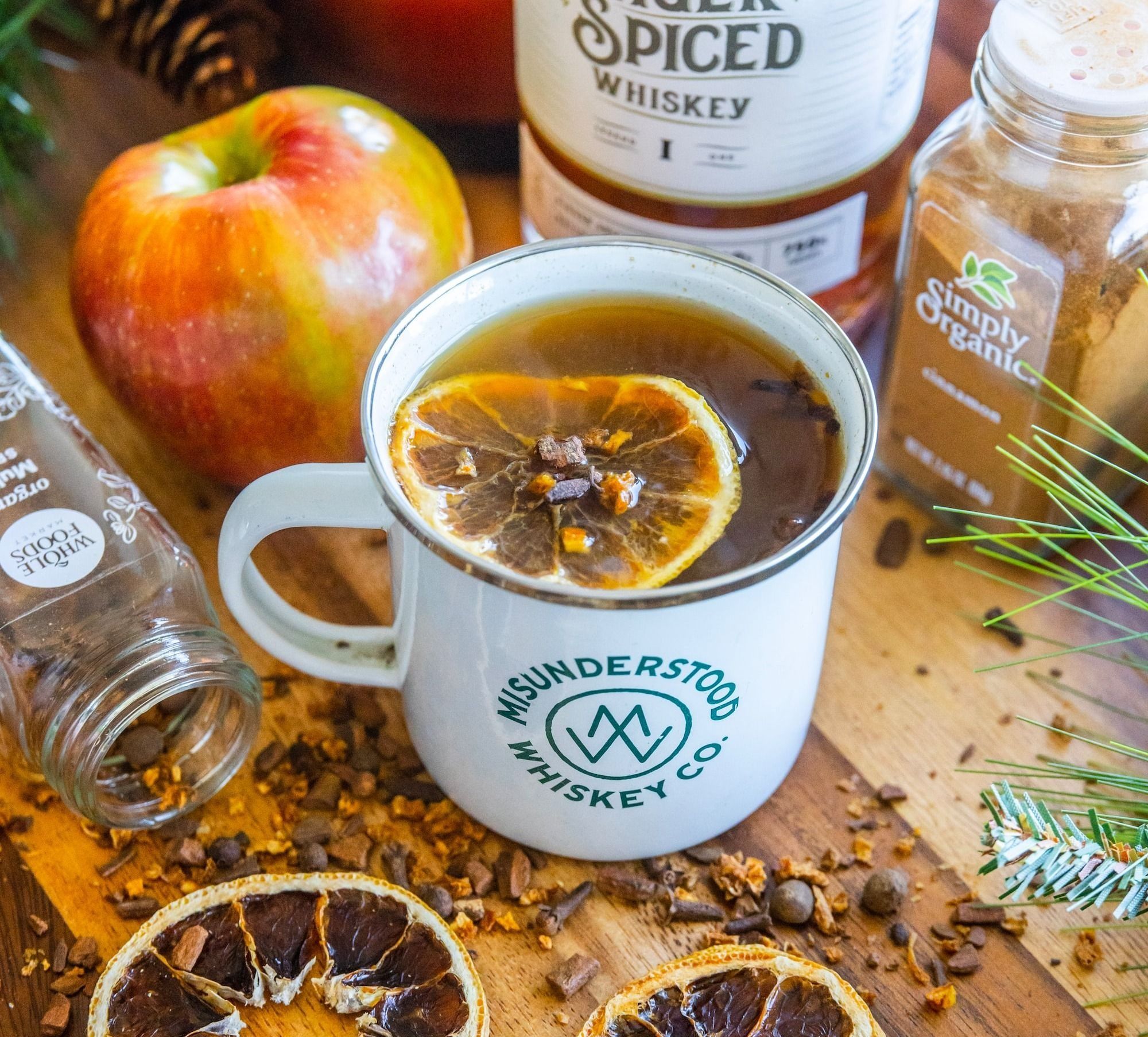 a cup of tea and some sliced oranges on a table with zero-proof whiskey