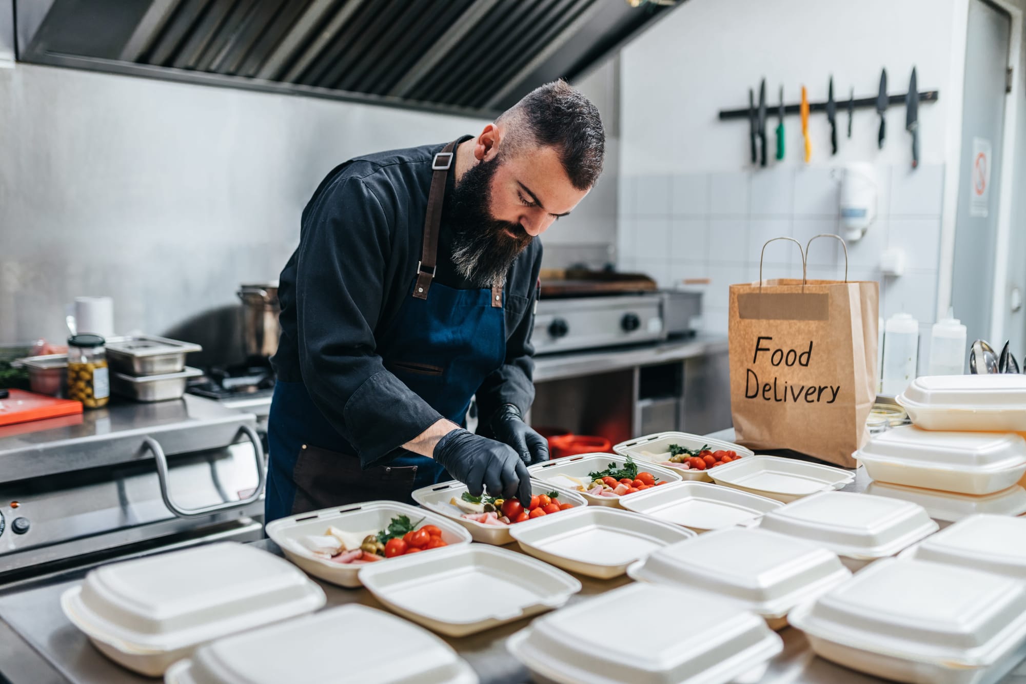 Man restaurant worker prepares orders for food delivery.