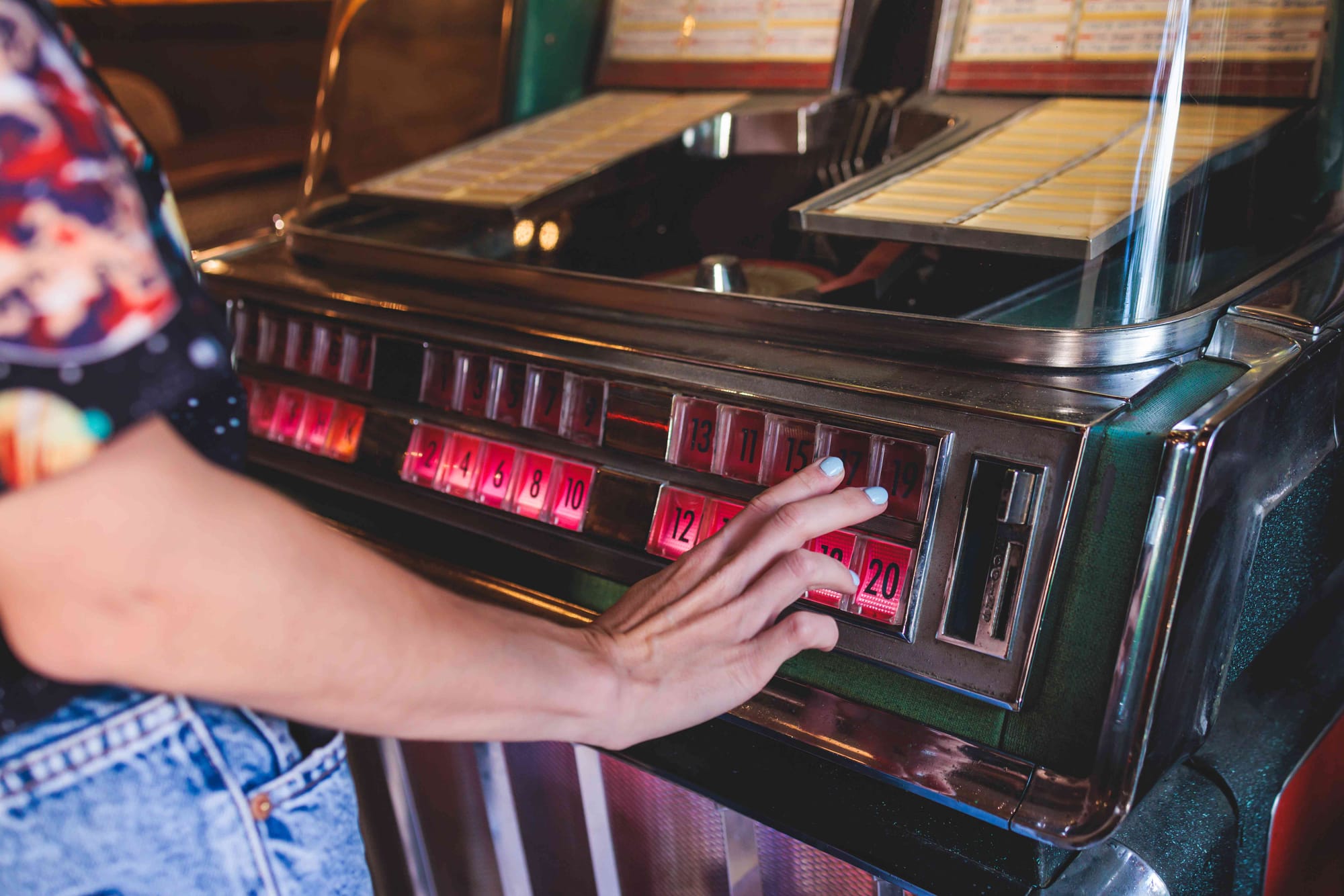A person makes a music selection from a vintage jukebox