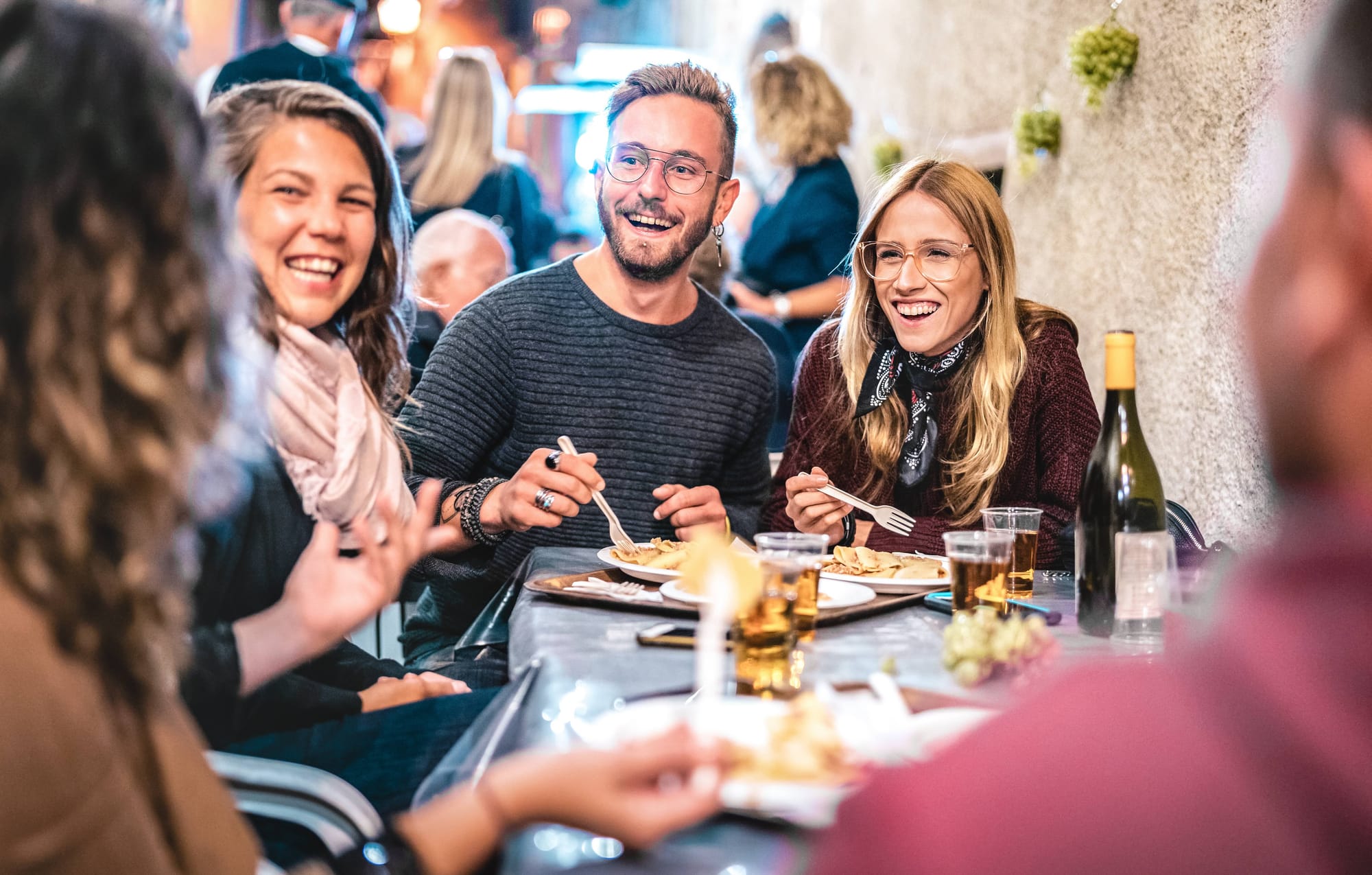 A group of 5 diners eat outside at a restaurant.