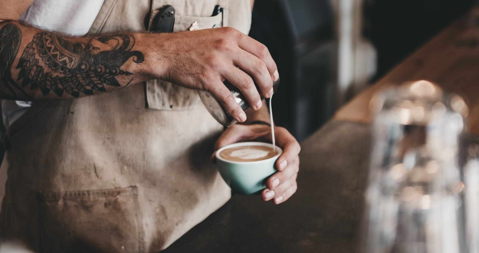 Man pouring mocha latte into a cup.