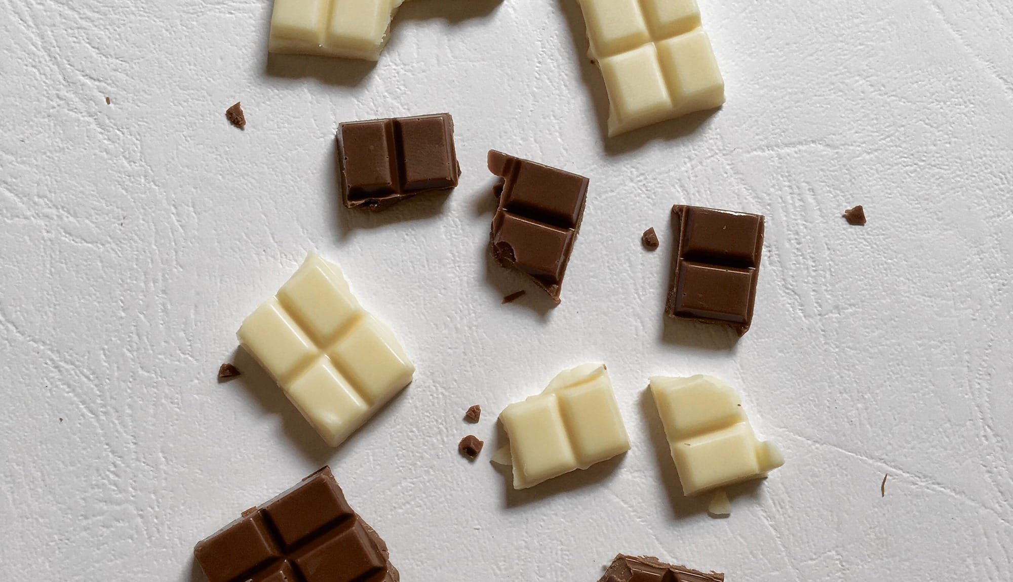 Dark chocolate and white chocolate on a counter.
