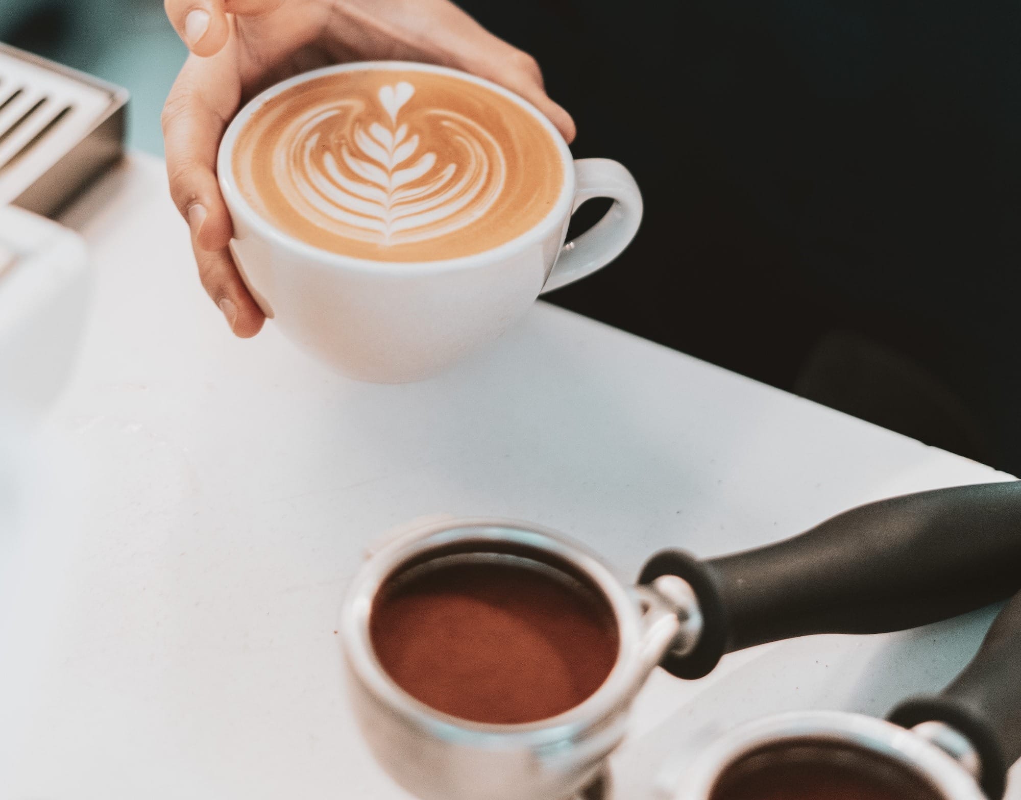 person pouring coffee on white ceramic cup