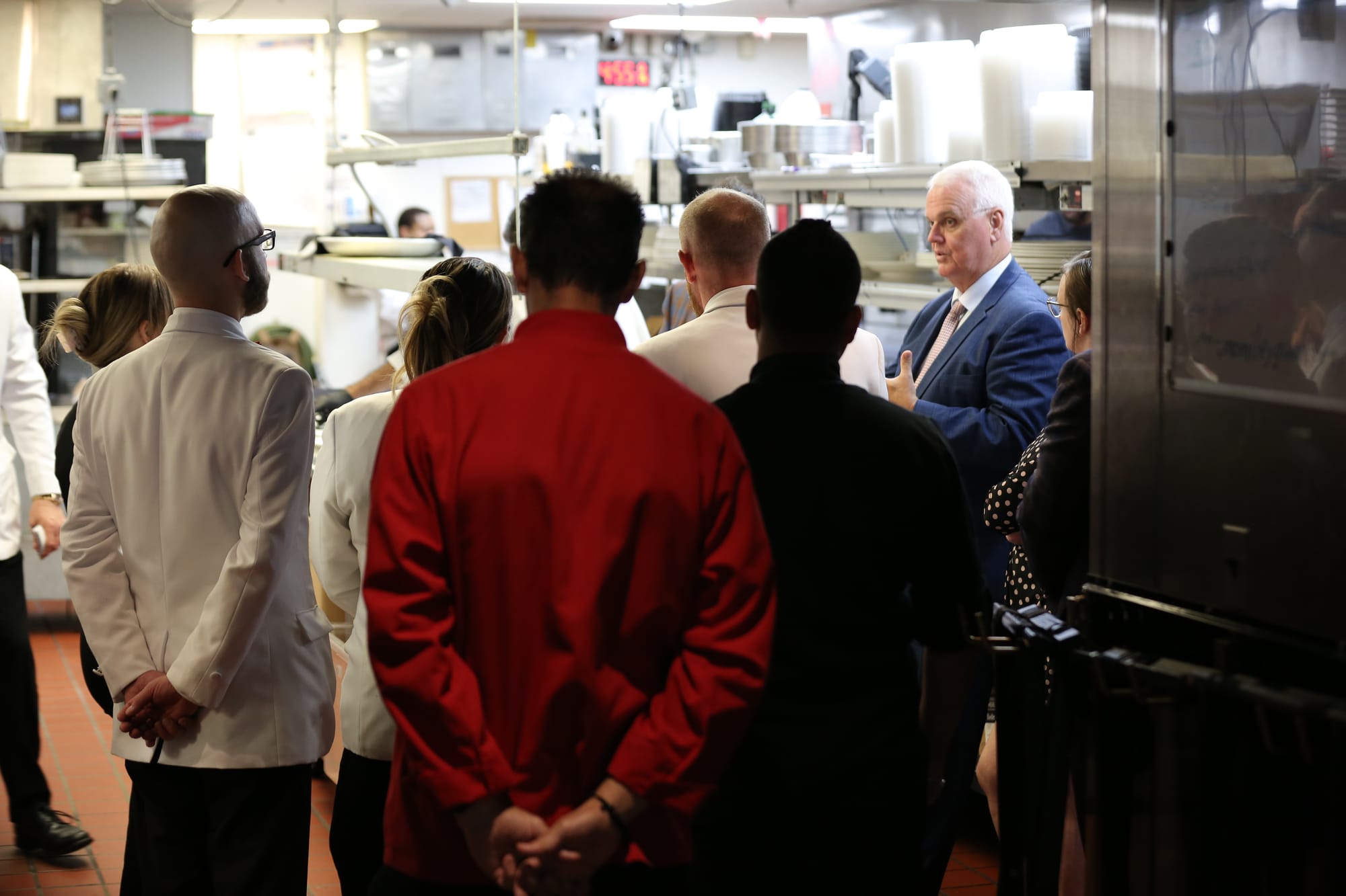 A pre-shift meeting in the kitchen of a restaurant