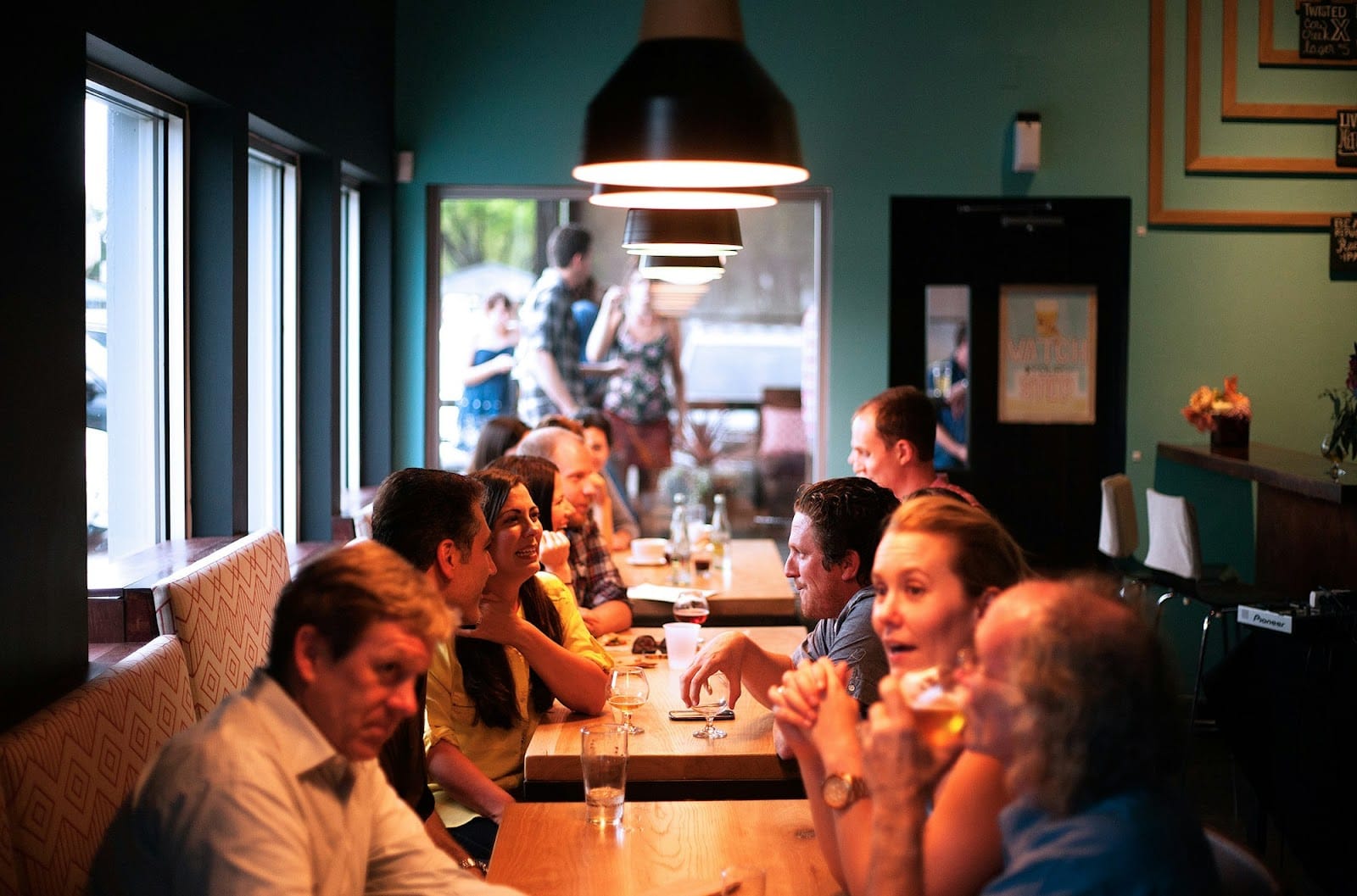 Row of guests at a restaurant talking and enjoying their time.