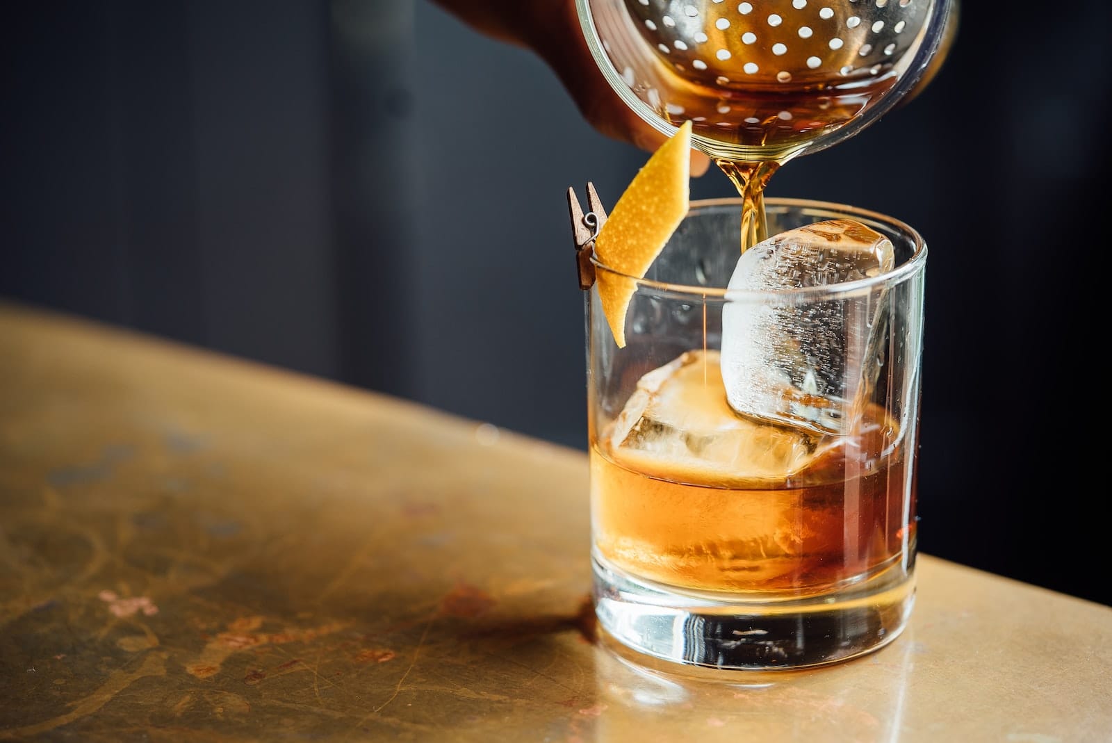 cocktail shaker liquor poured on clear shot glass