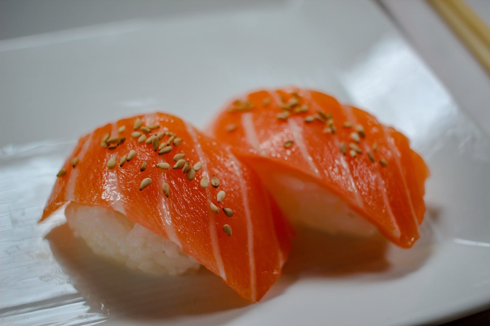 sliced orange nigiri sushi on white ceramic plate