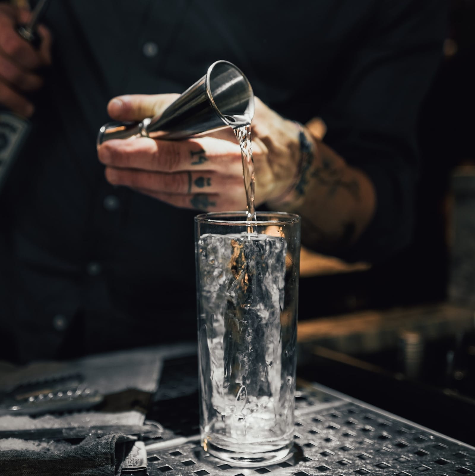 person pouring water on clear drinking glass