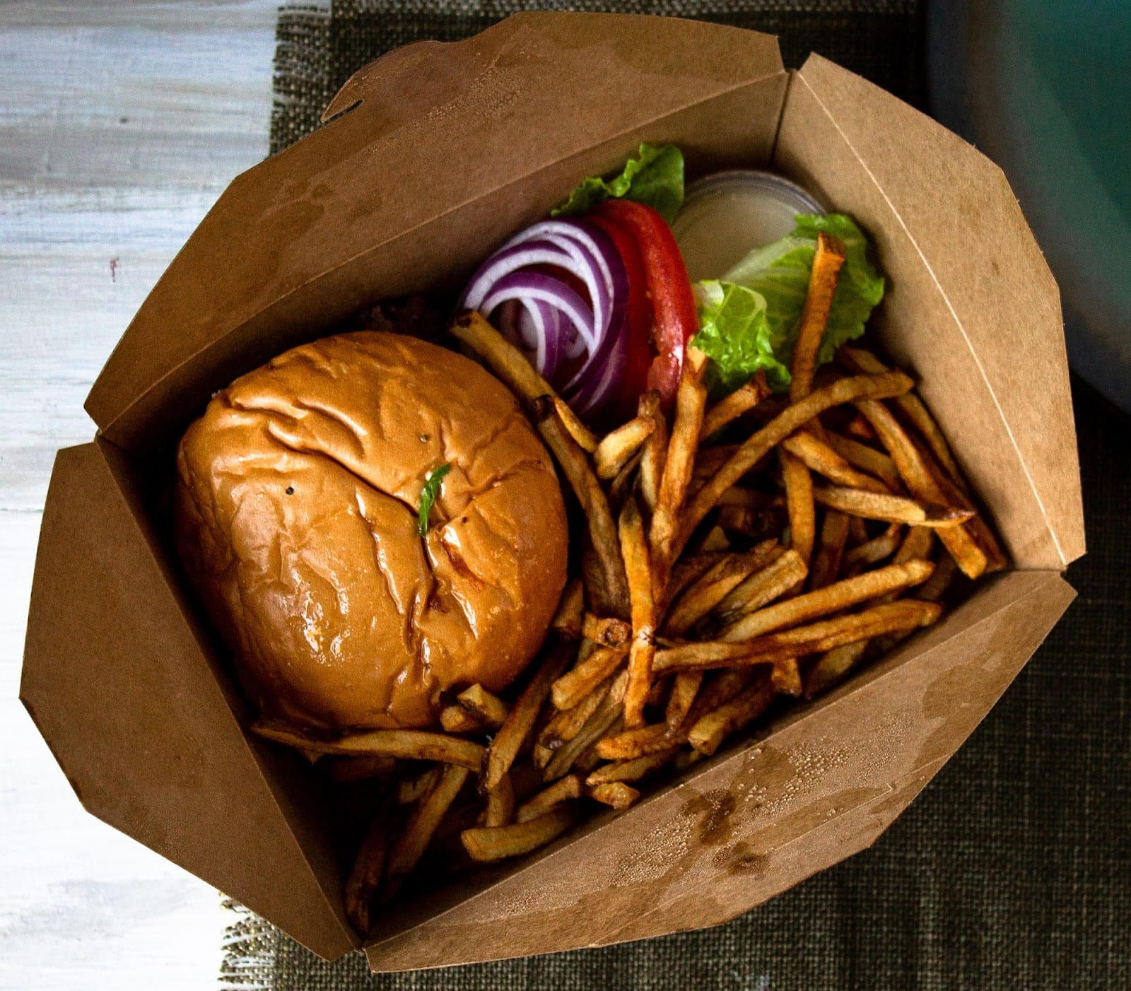 Burger and fries in a takeout box