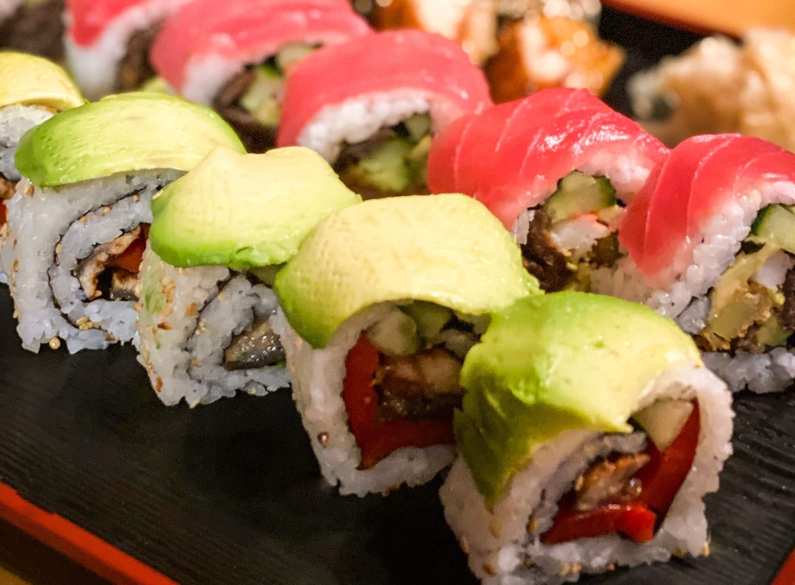 Sushi dish with avocado and salmon rolls.