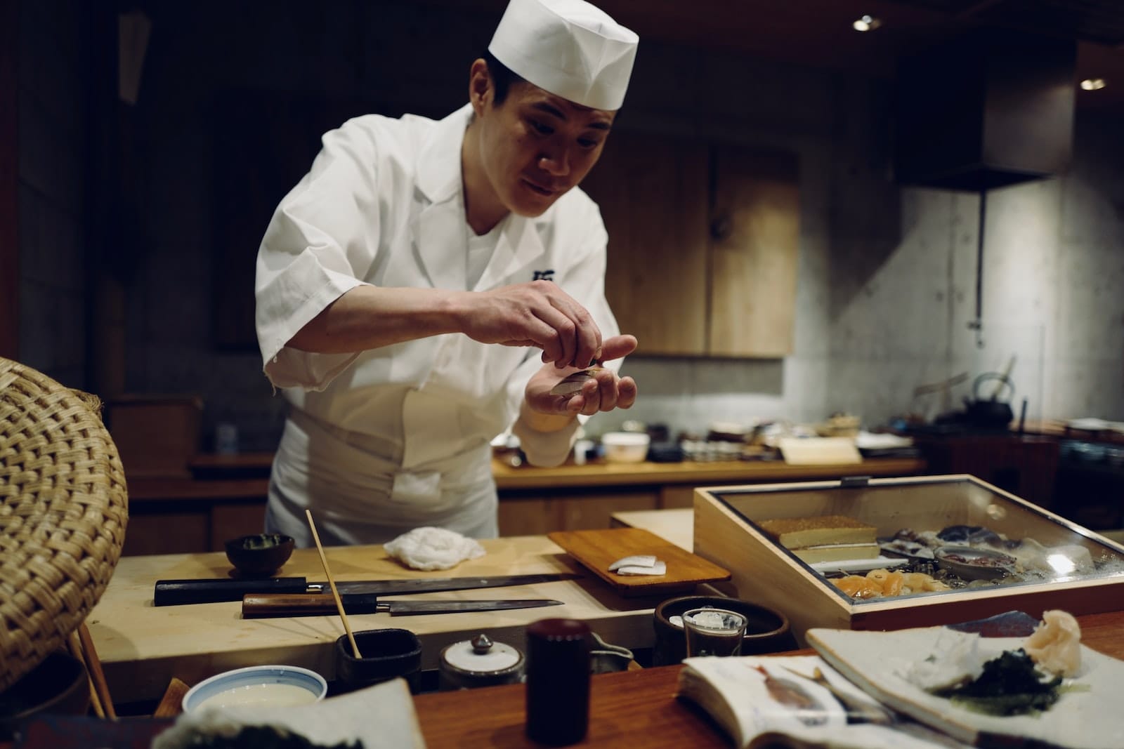 Sushi chef preparing nigiri, sashimi and other sushi for guests.