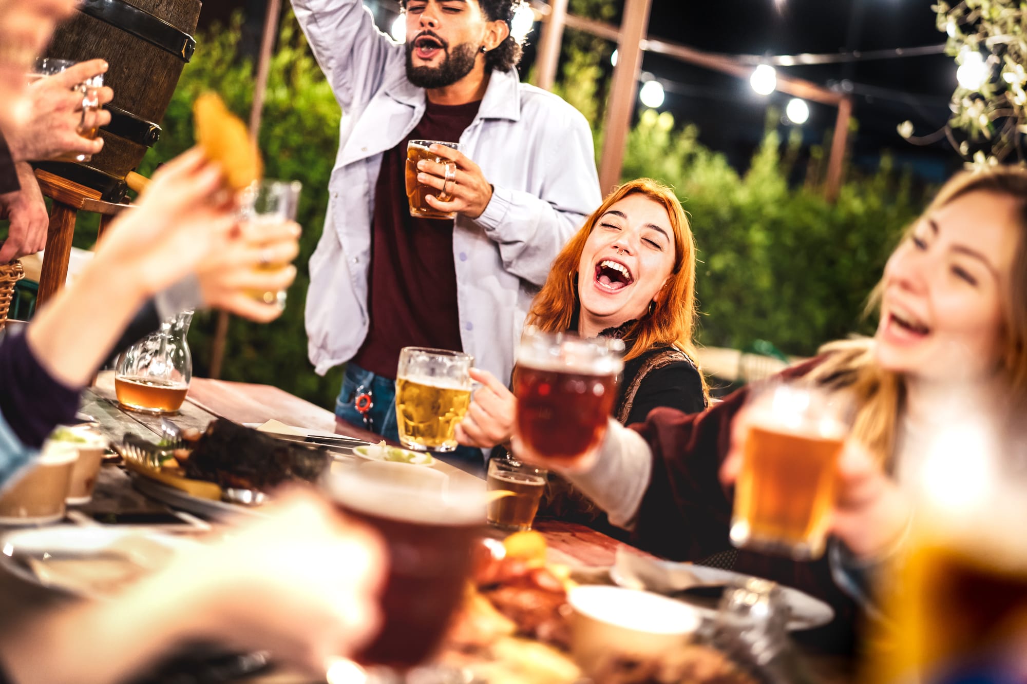 Patrons at a bar gastro pub bistro sharing drinks and beers and cheering to the great bar bistro staff service.