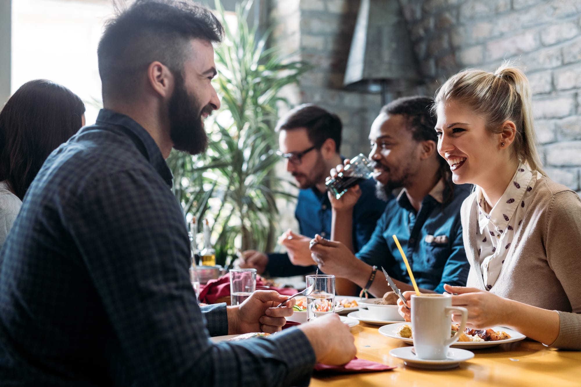 People sitting at a bistro restaurant table eating and talking and laughing on a restaurant date