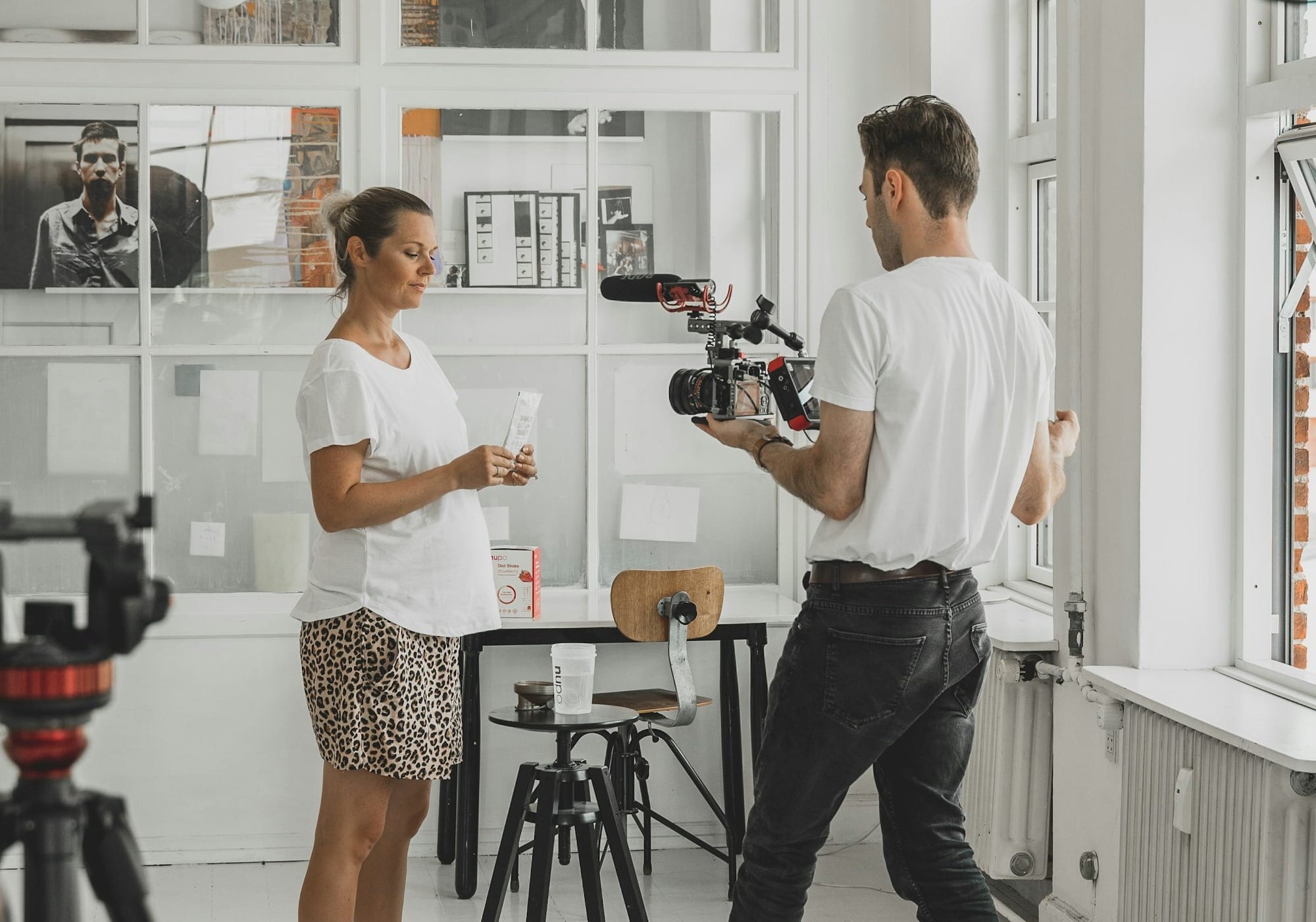 A cameraman films a small business owner