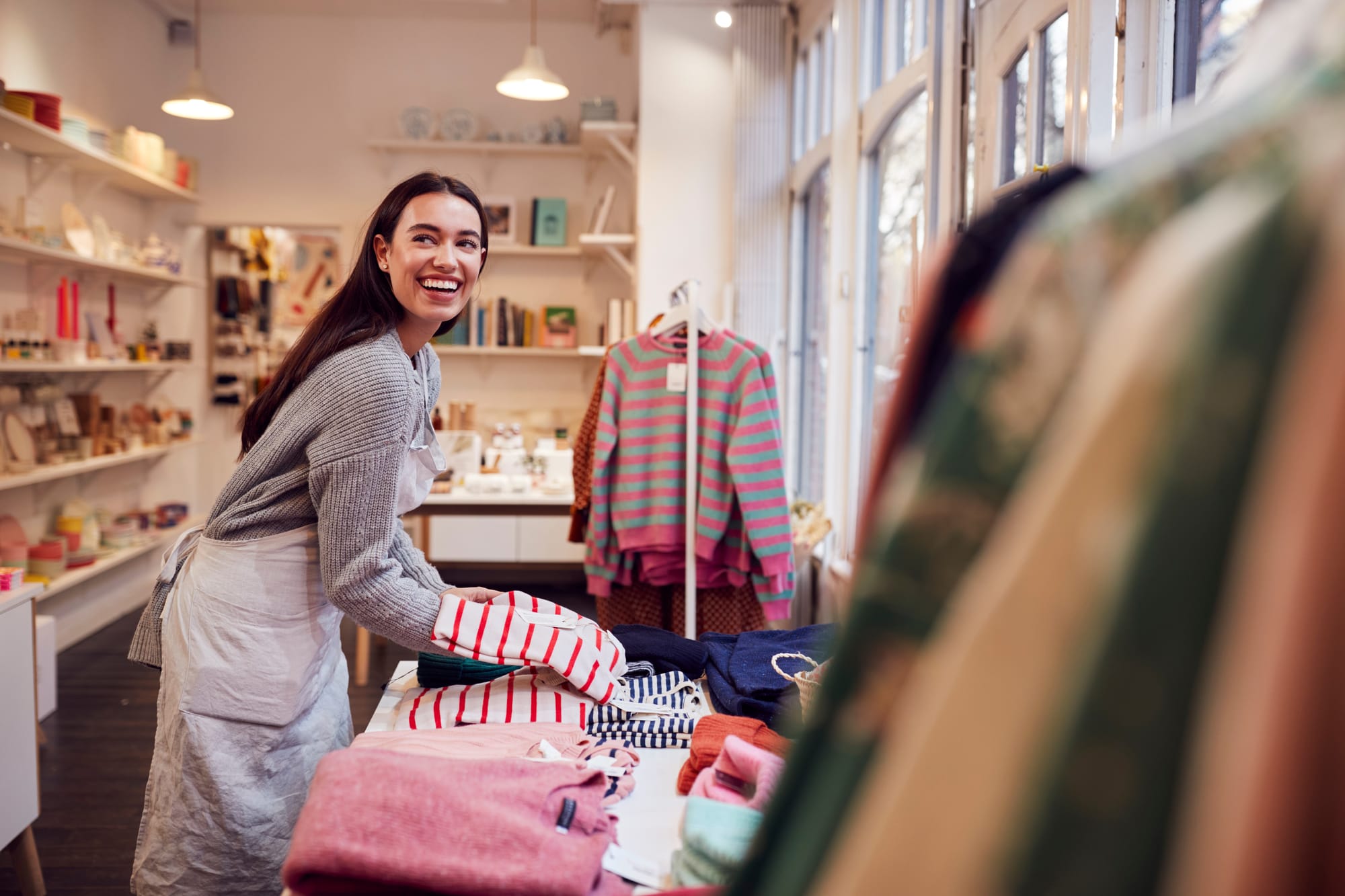 Retail worker folding and working with clothes inventory