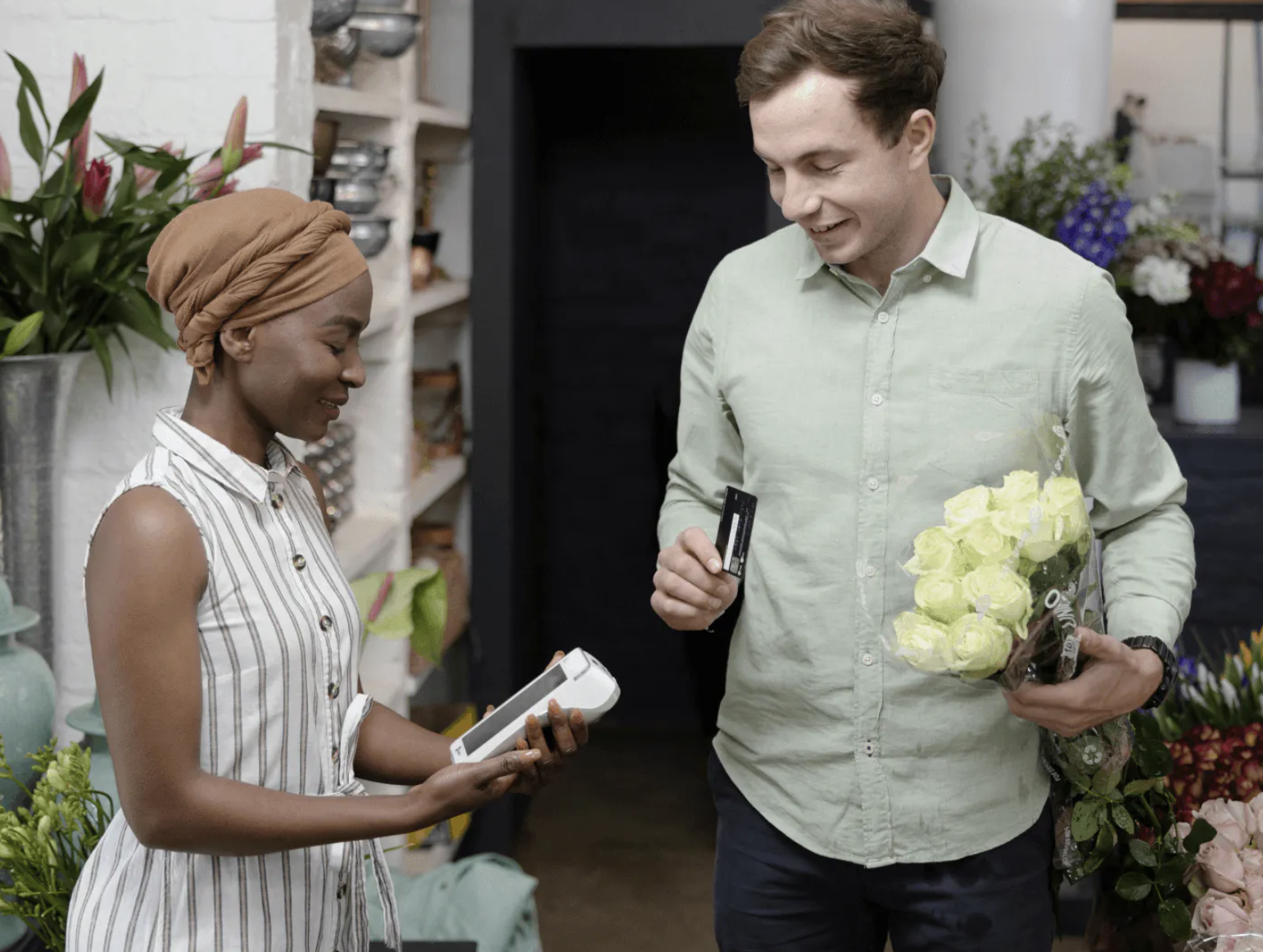 Eager customer in a retail shop purchasing flowers from a handheld mobile POS device