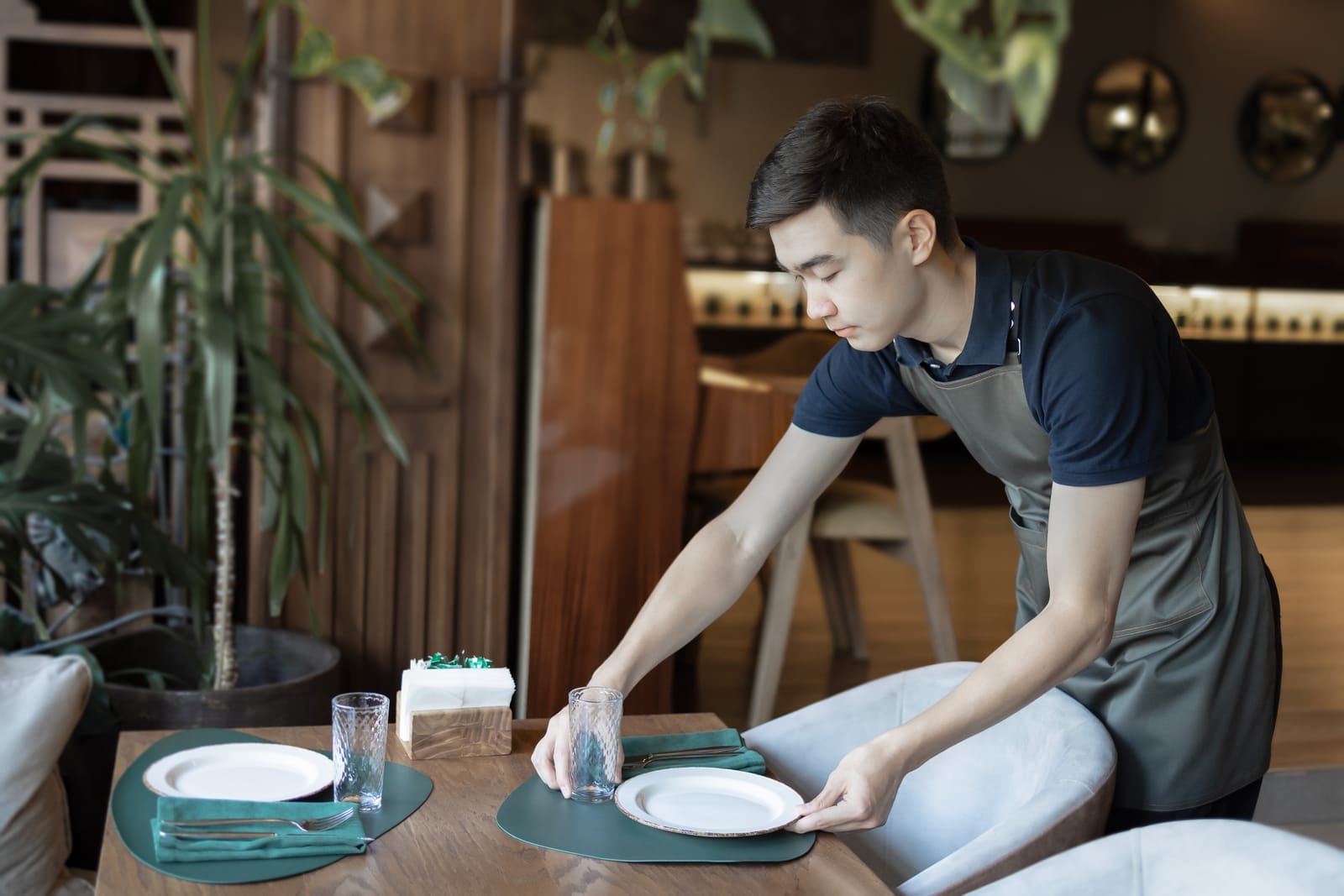 Restaurant staff waiter placing plate on table in restaurant for prix fixe menu dinner