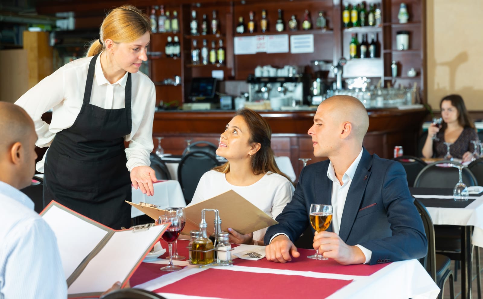 Guests ordering from waitress in restaurant serving a prix fixe menu lunch dinner special