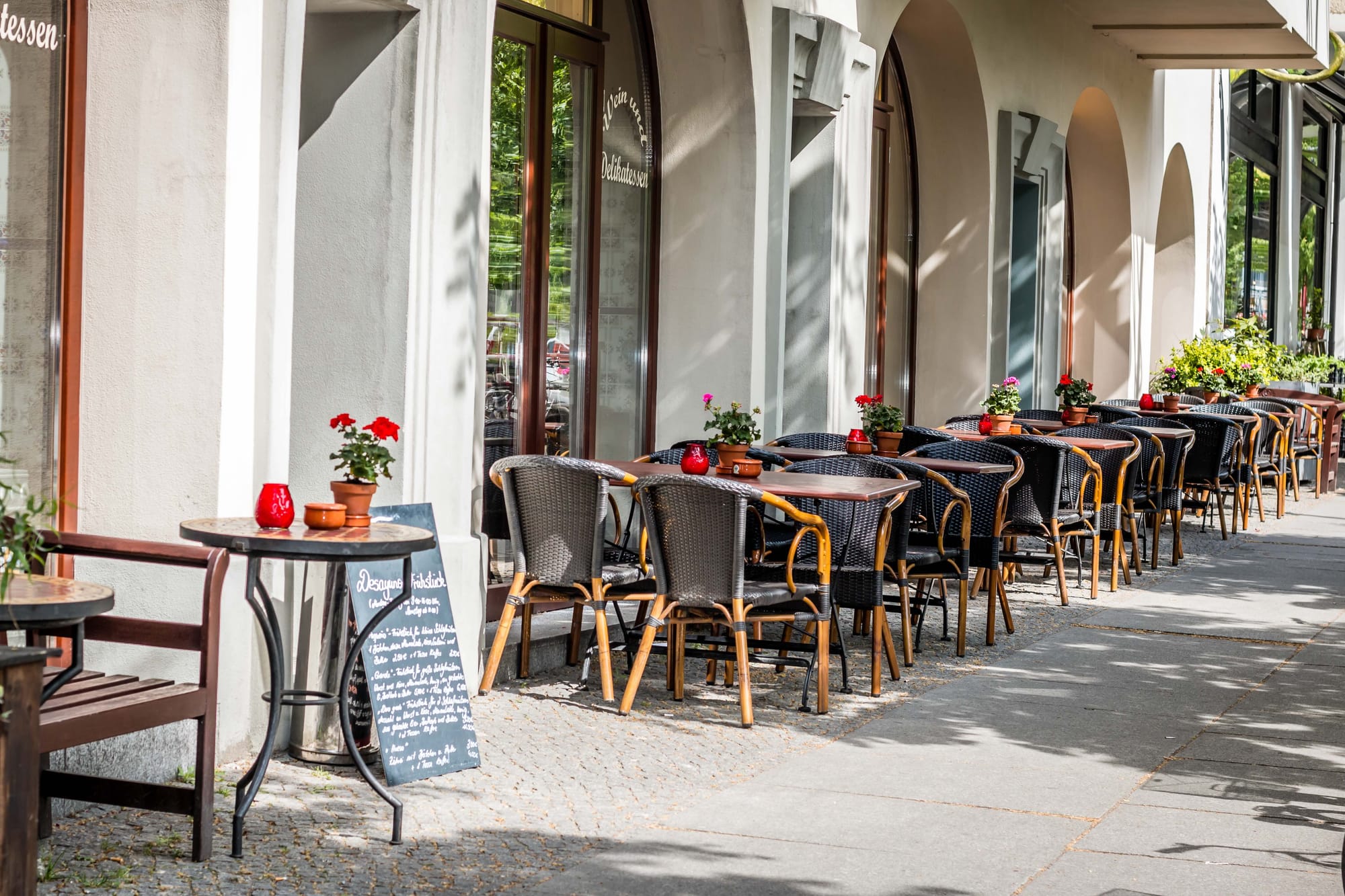 Tables and chairs outside the front of a restaurant.