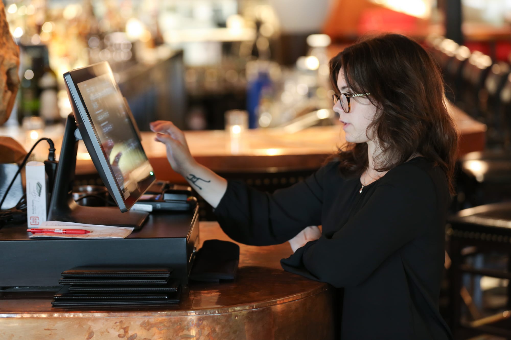 Michigan restaurant employee working at SpotOn point-of-sale system touchscreen