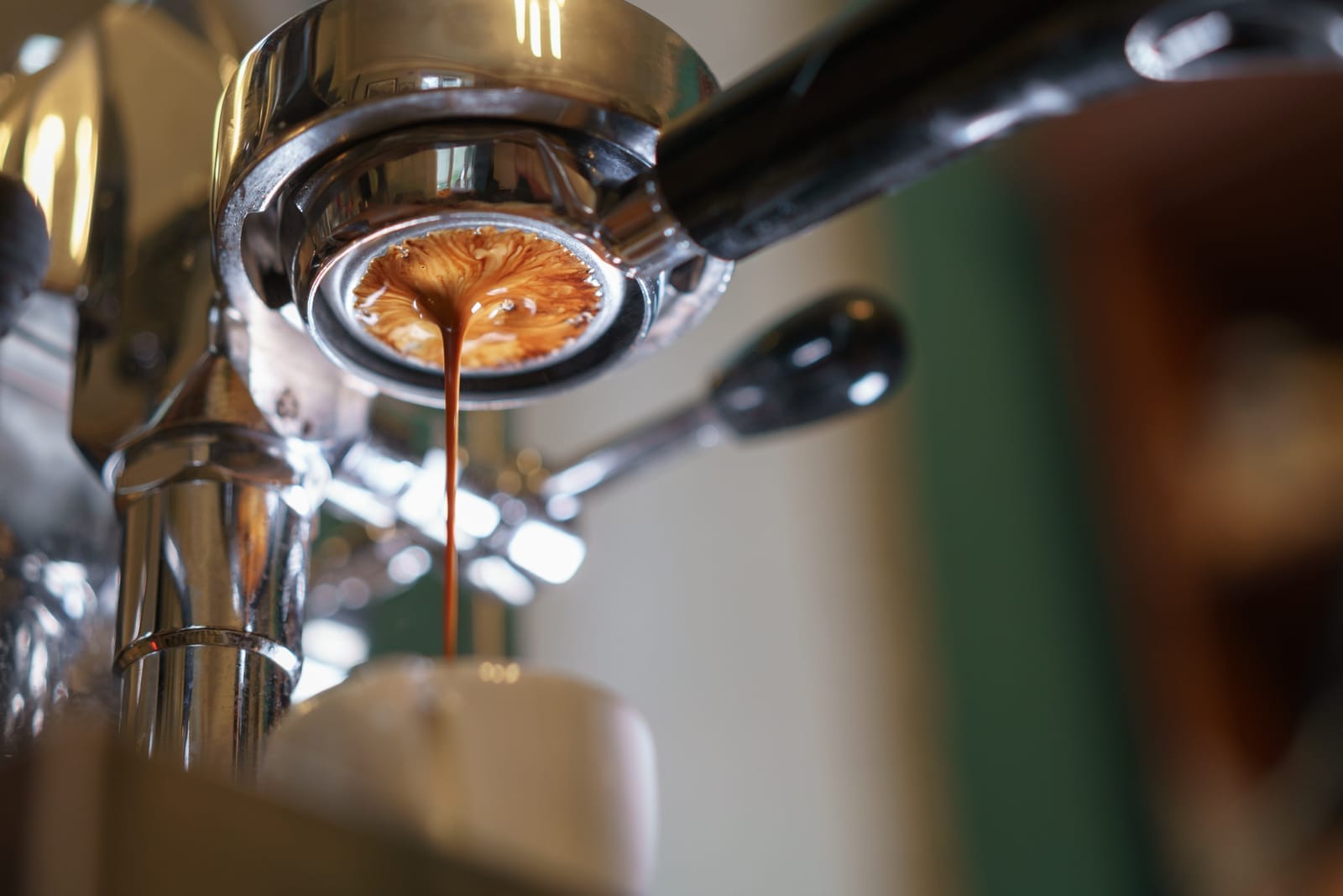 Espresso pouring from machine into cup with an even flow.