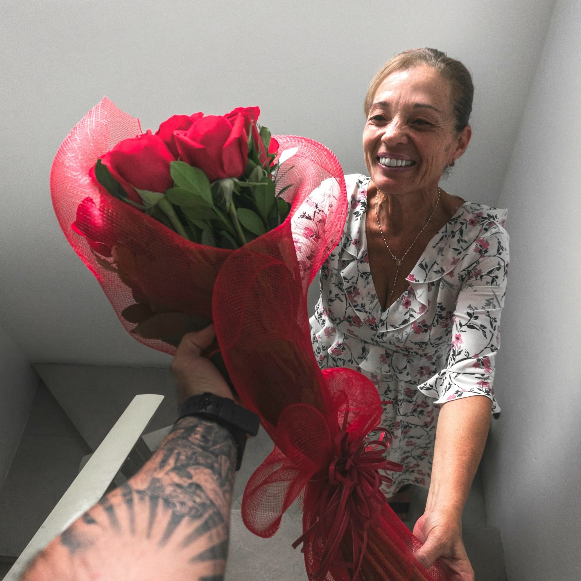 smiling woman receiving bouquet of red roses